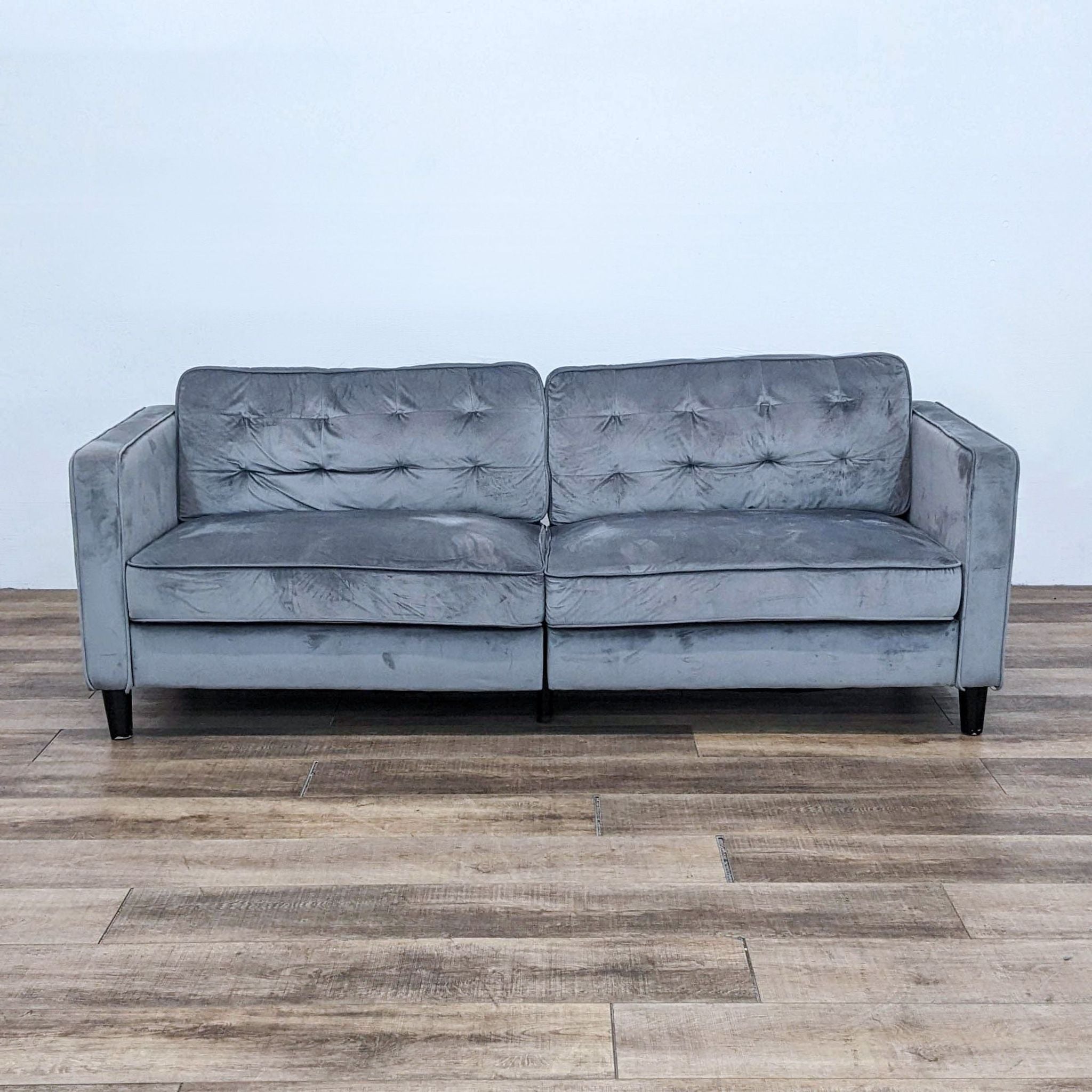 Reperch 3-seat tufted back sofa with two cushions and track arms, dark feet, front view on wooden floor.