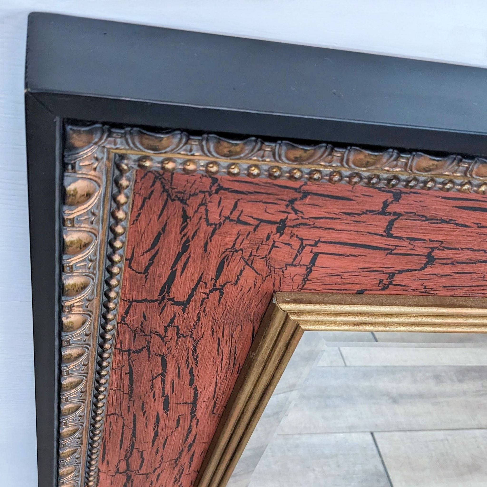 Close-up of John Richard beveled mirror's frame, showcasing the detailed crackle finish and gold accents.