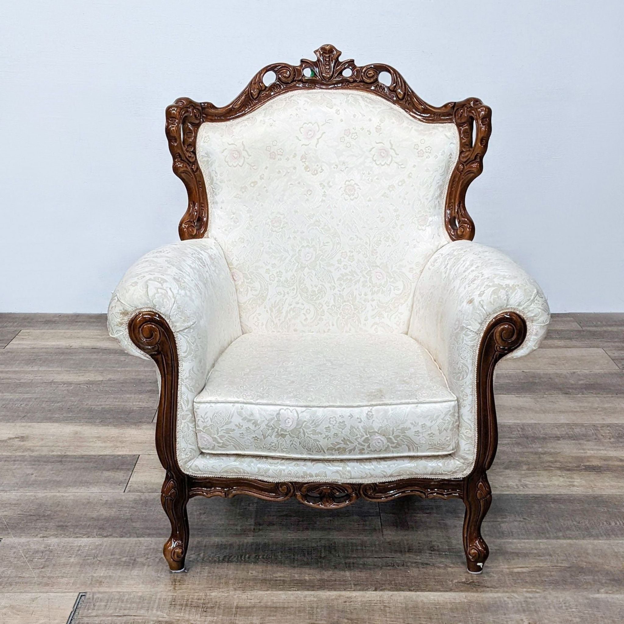 1. Reperch vintage style armchair with cream embossed upholstery and dark wooden ornate frame on a wooden floor.