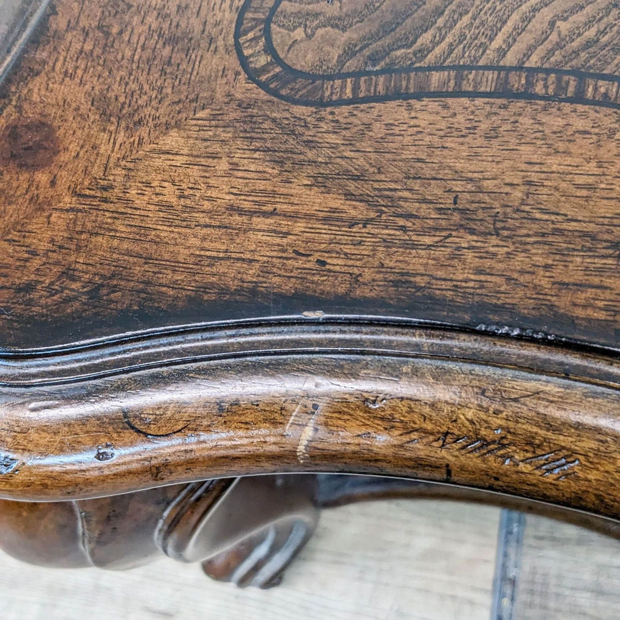 Close-up of a Thomasville coffee table's inlaid top and carved cabriole leg detailing.