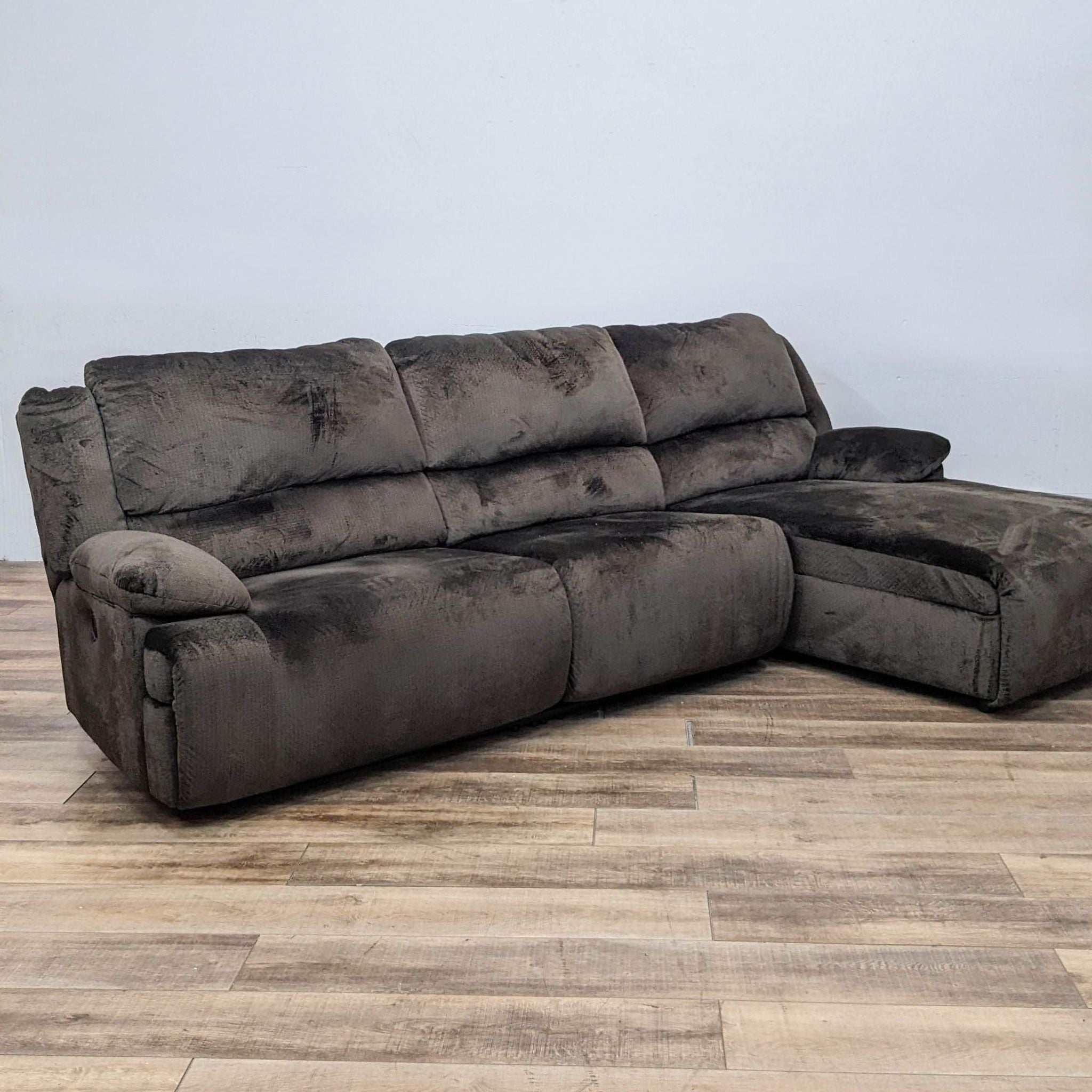 Alt text 1: Brown Reperch brand fabric sectional with a reclined end and a chaise lounge in a room with wooden flooring.
