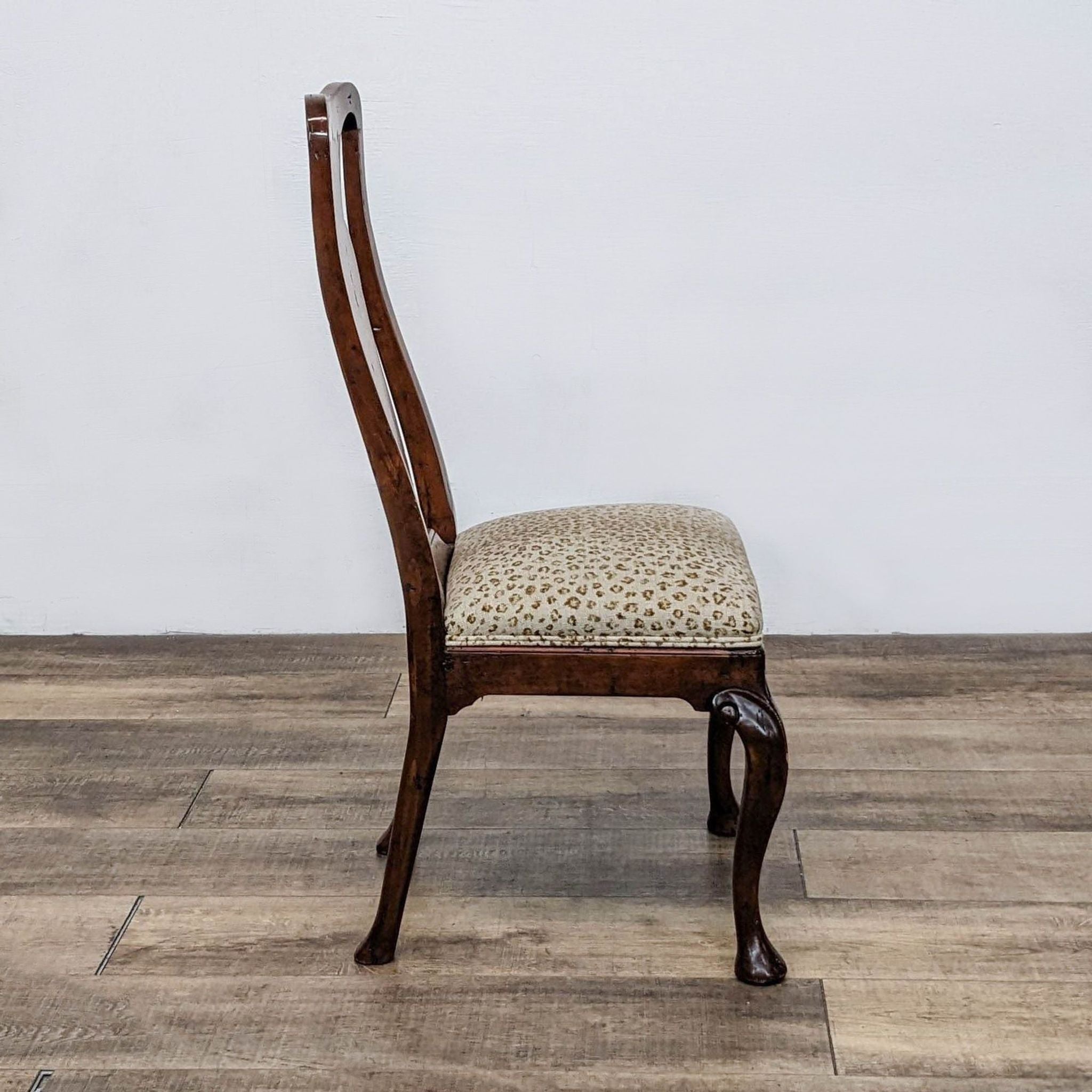 Reperch brand dining chairs featuring leopard upholstery and curvaceous Queen Anne style wooden legs, displayed against a white wall.