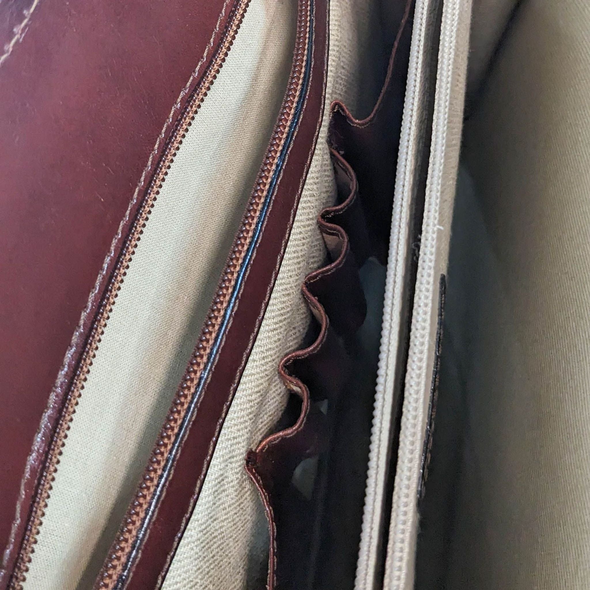 Close-up of an open Bosca leather purse revealing its fabric interior, stitching details, and pocket structure.