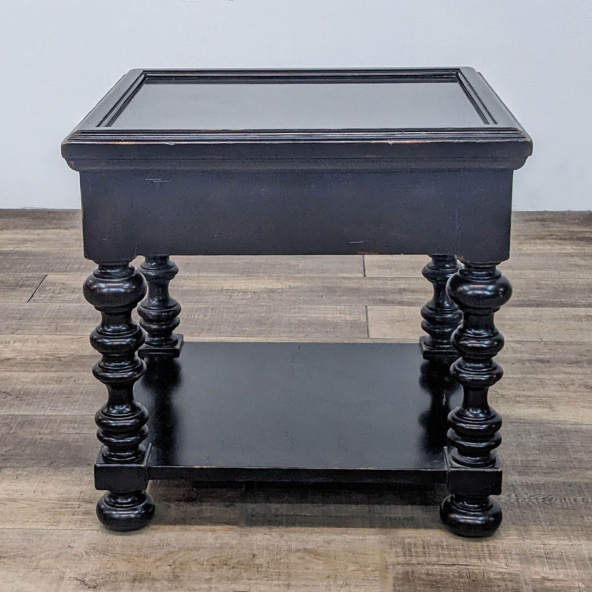 Distressed black end table by Tommy Bahama with a drawer and shelf, detailed spindle legs, and a rustic finish.