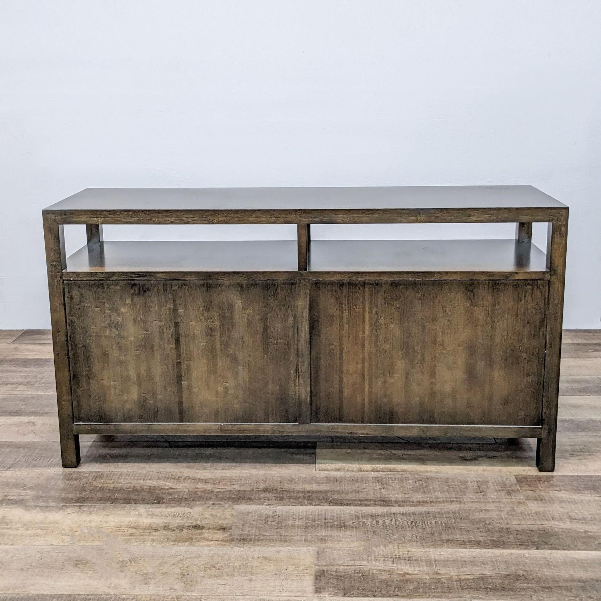 Crate & Barrel wooden entertainment center with glass shelves on a wood-patterned floor.