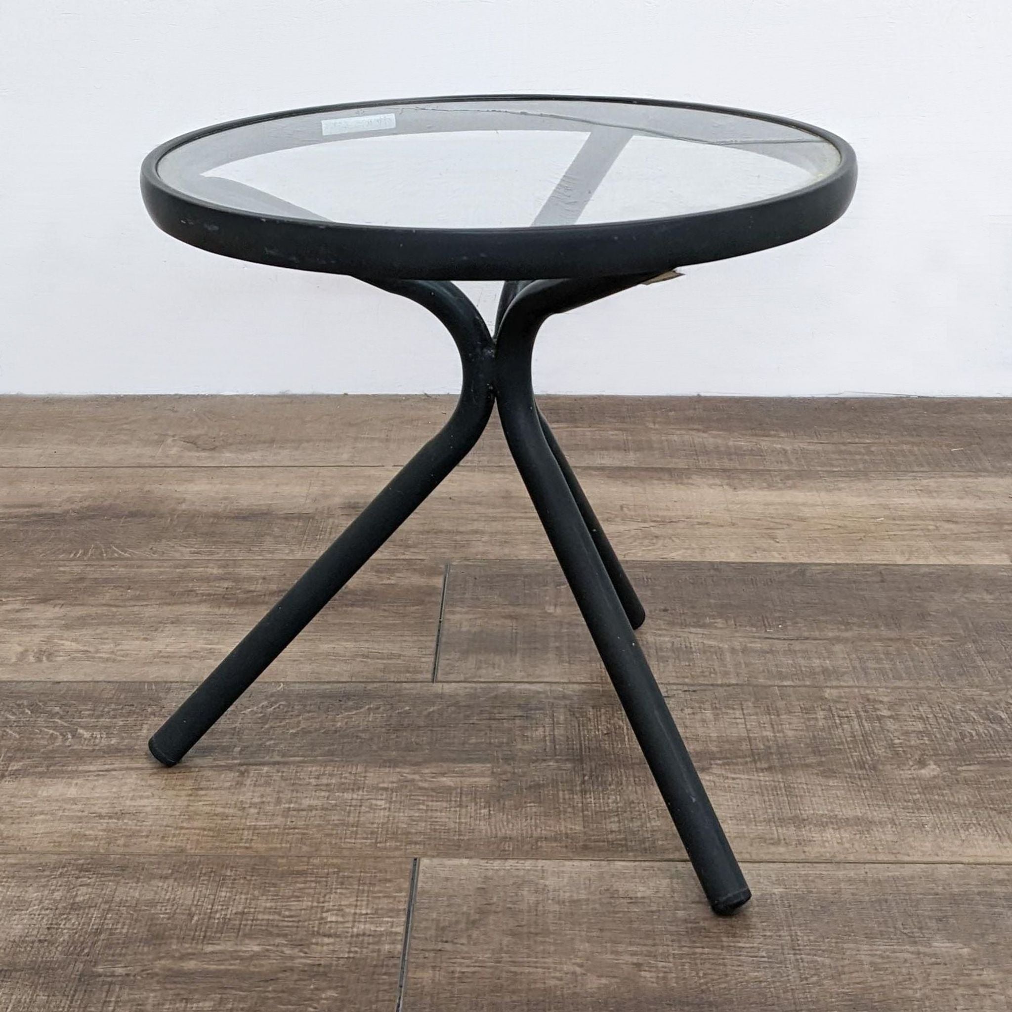 Brown Jordan 18" round aluminum frame accent table with glass top, set on a wooden floor.