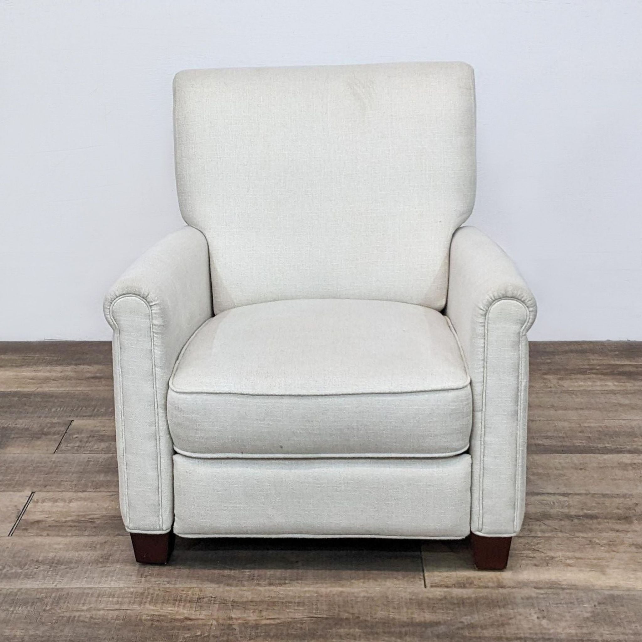 Pottery Barn beige upholstered armchair on a wooden floor, front view.