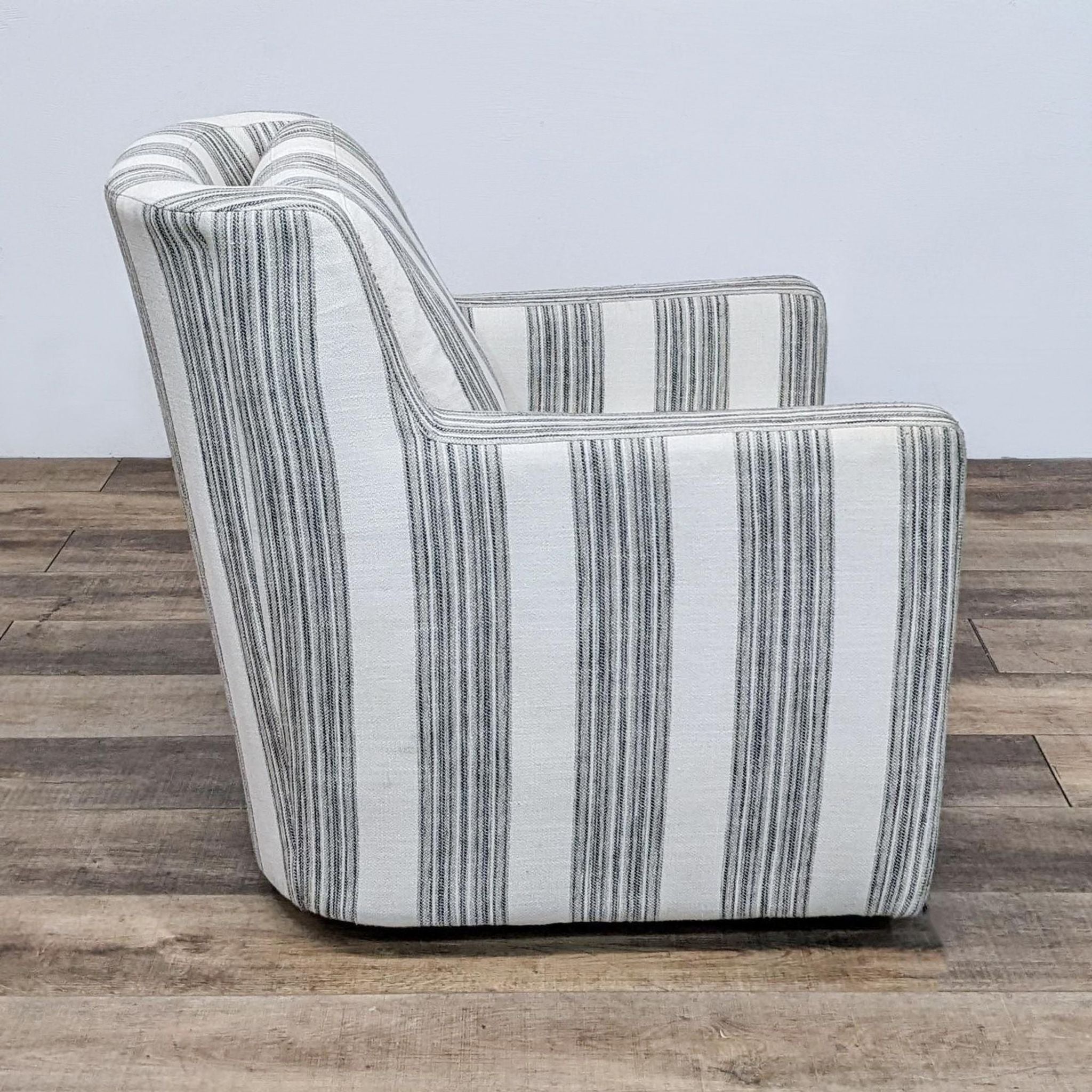 Comfort Design lounge swivel chair with vertical ivory and black stripes, viewed from the side, featuring a curved back.