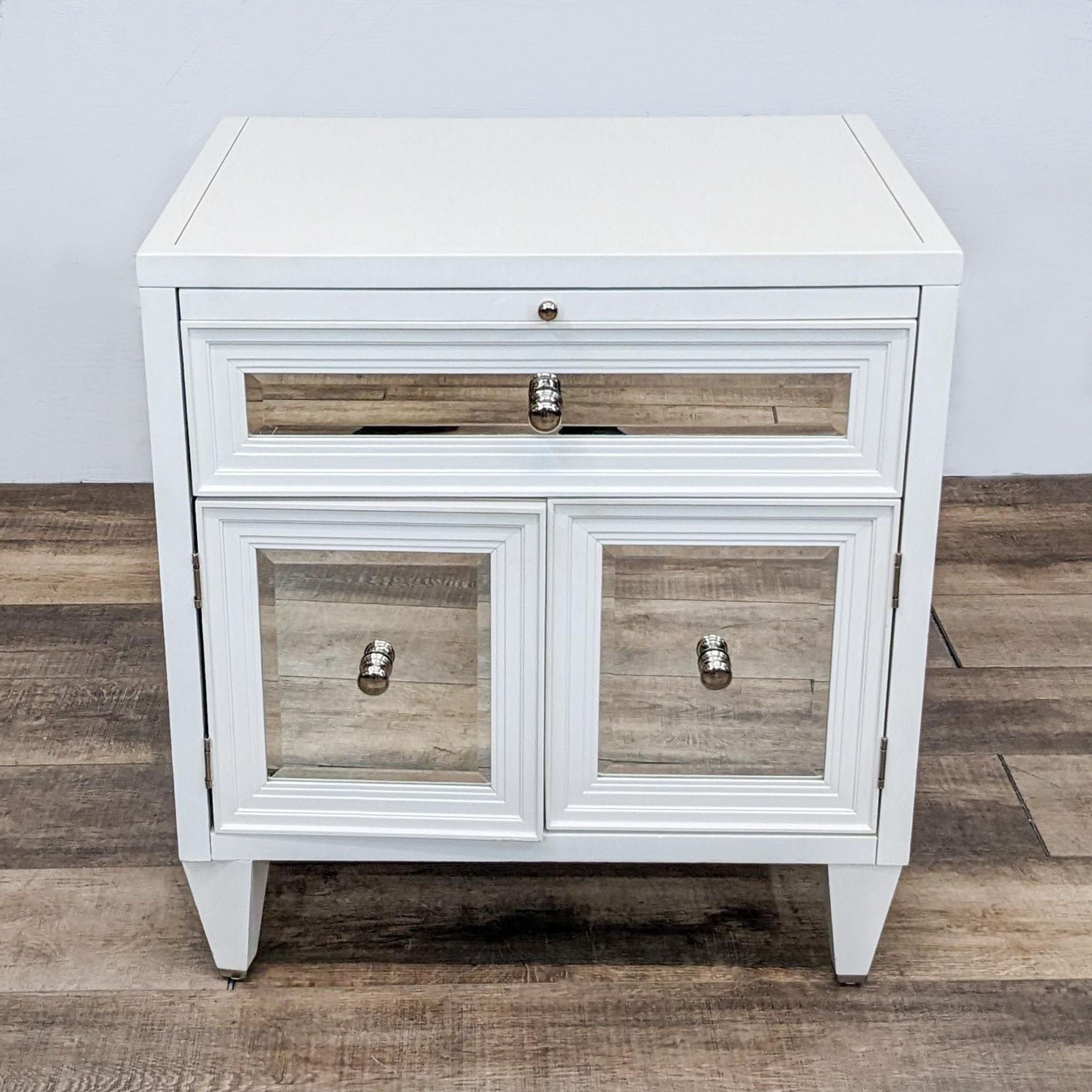 Z Gallerie end table with stepped moulding and beveled mirror accents, featuring a drawer and cabinet doors. 