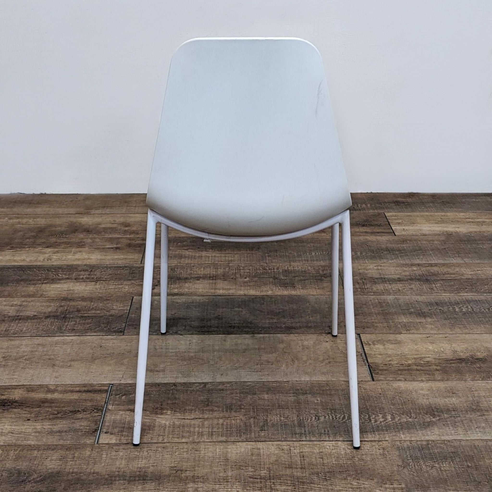 Reperch brand dining chair with polypropylene scooped seat and powder-coated metal legs on wooden floor.