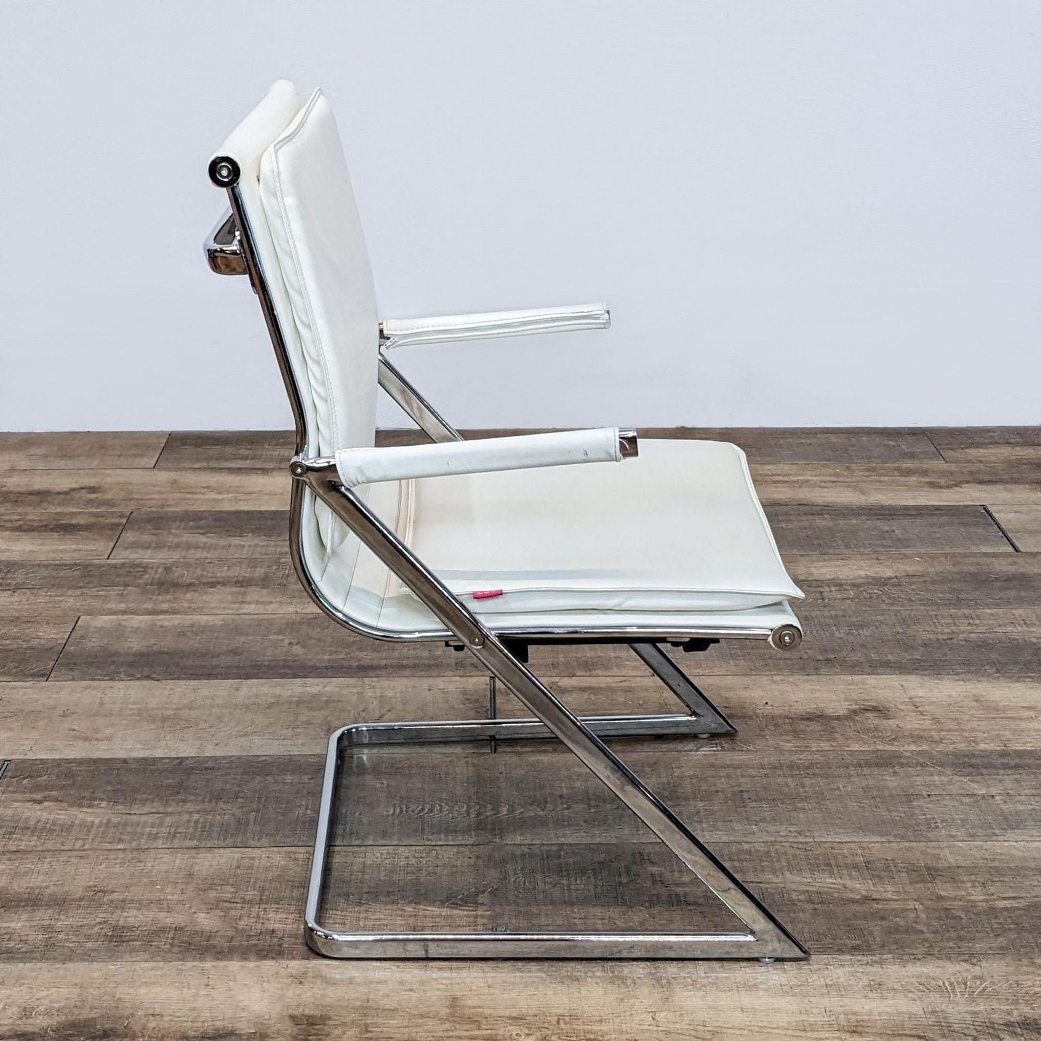 Side view of Zuo Modern white leather chair with sleek chrome frame against plain background.