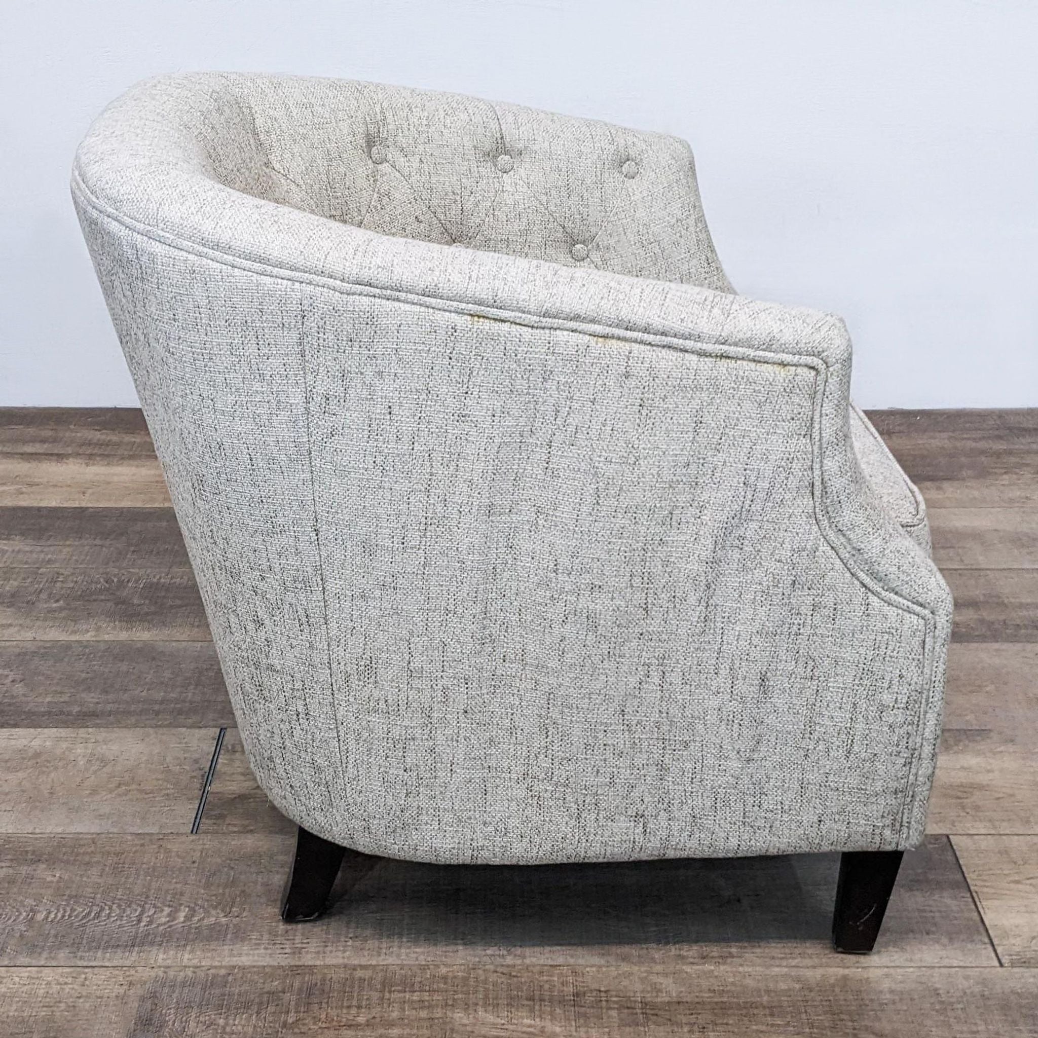 Reperch barrel back chair featuring tufted upholstery and wood legs, in a side and back perspective.