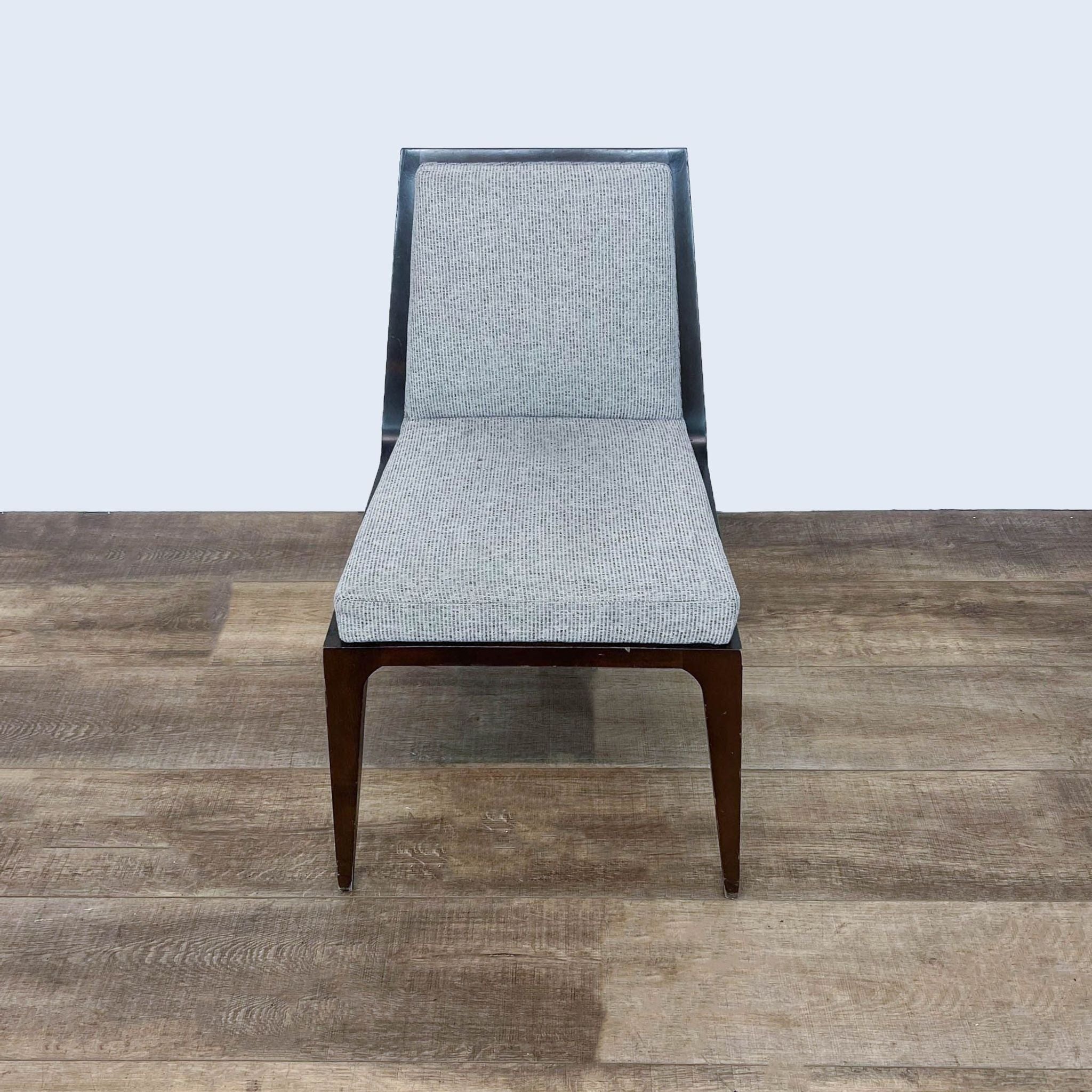 Kimball International dining chair with a sleek design and gray fabric on a wooden floor.