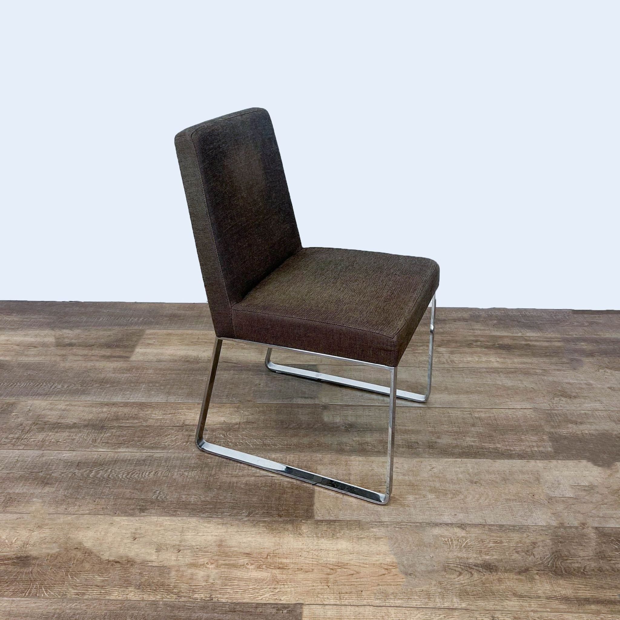 Alt text 2: Modern Calligaris dining chair featuring brown fabric upholstery and a sleek curved steel base, displayed on wooden flooring.