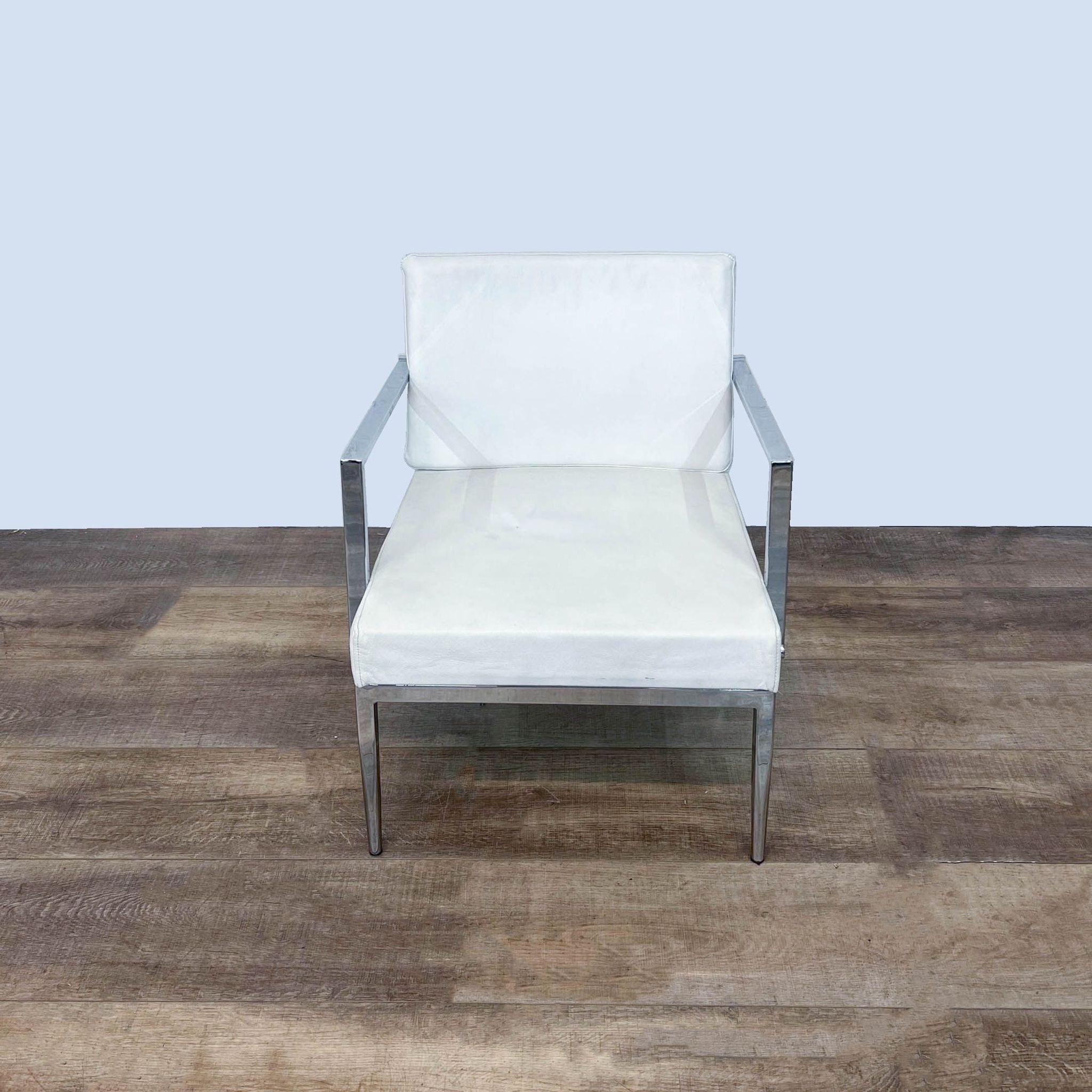 Reperch modern white leather armchair with a curved back and chrome metal frame, displayed from the front.