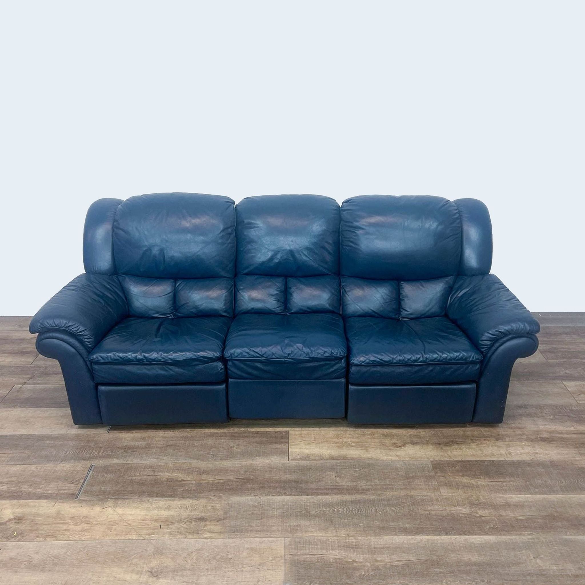 Dark blue Reperch leather sofa with high back and pillow top arms, shown from the front.