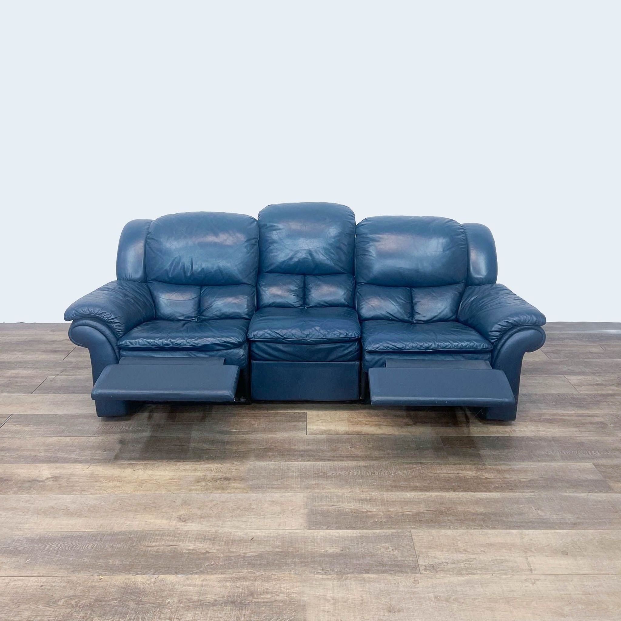 Reperch 3-seat leather sofa in dark blue with reclining seats, depicted with one seat partially reclined.