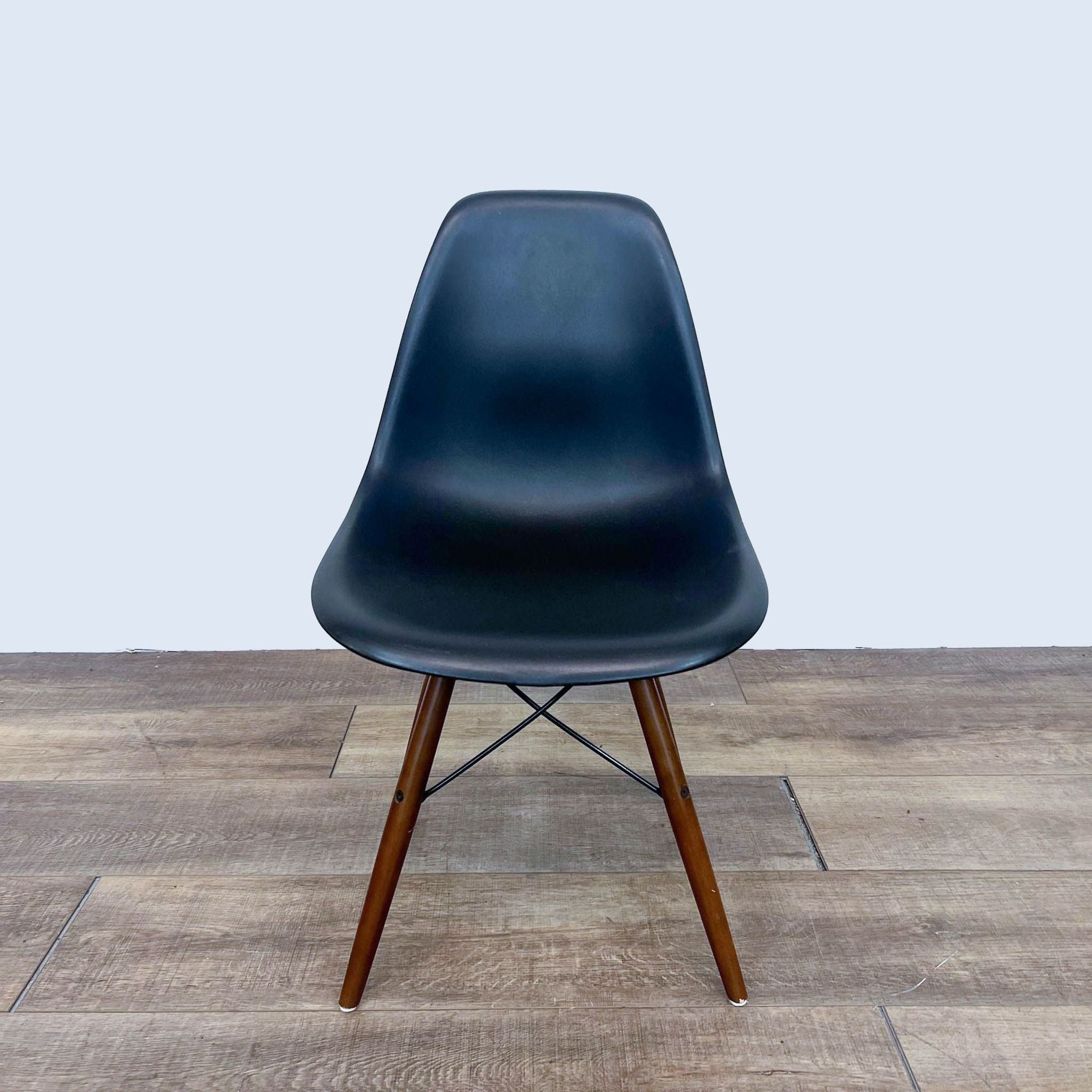 Black Reperch dining chair with contoured seat and walnut-finish Eiffel base, front view.