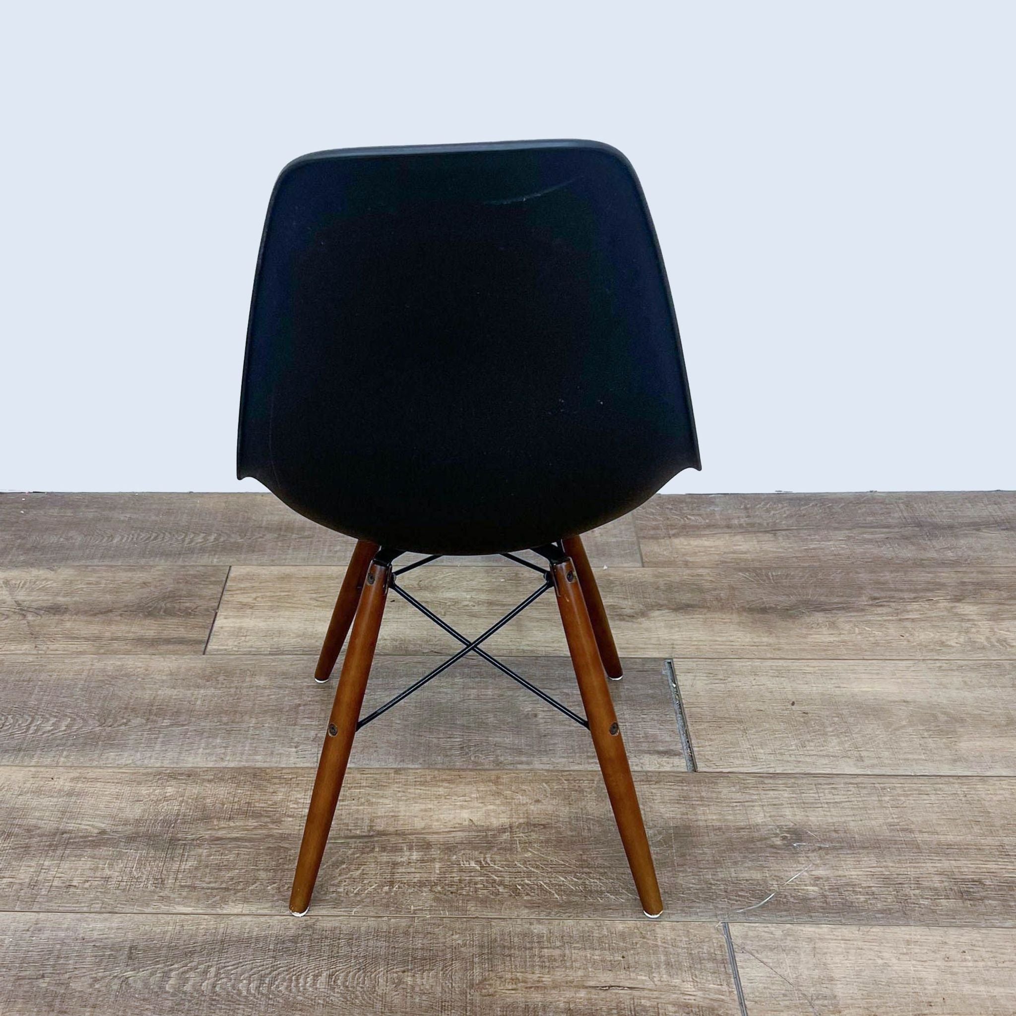 Reperch dining chair with a black molded seat and walnut-finish Eiffel-style base.