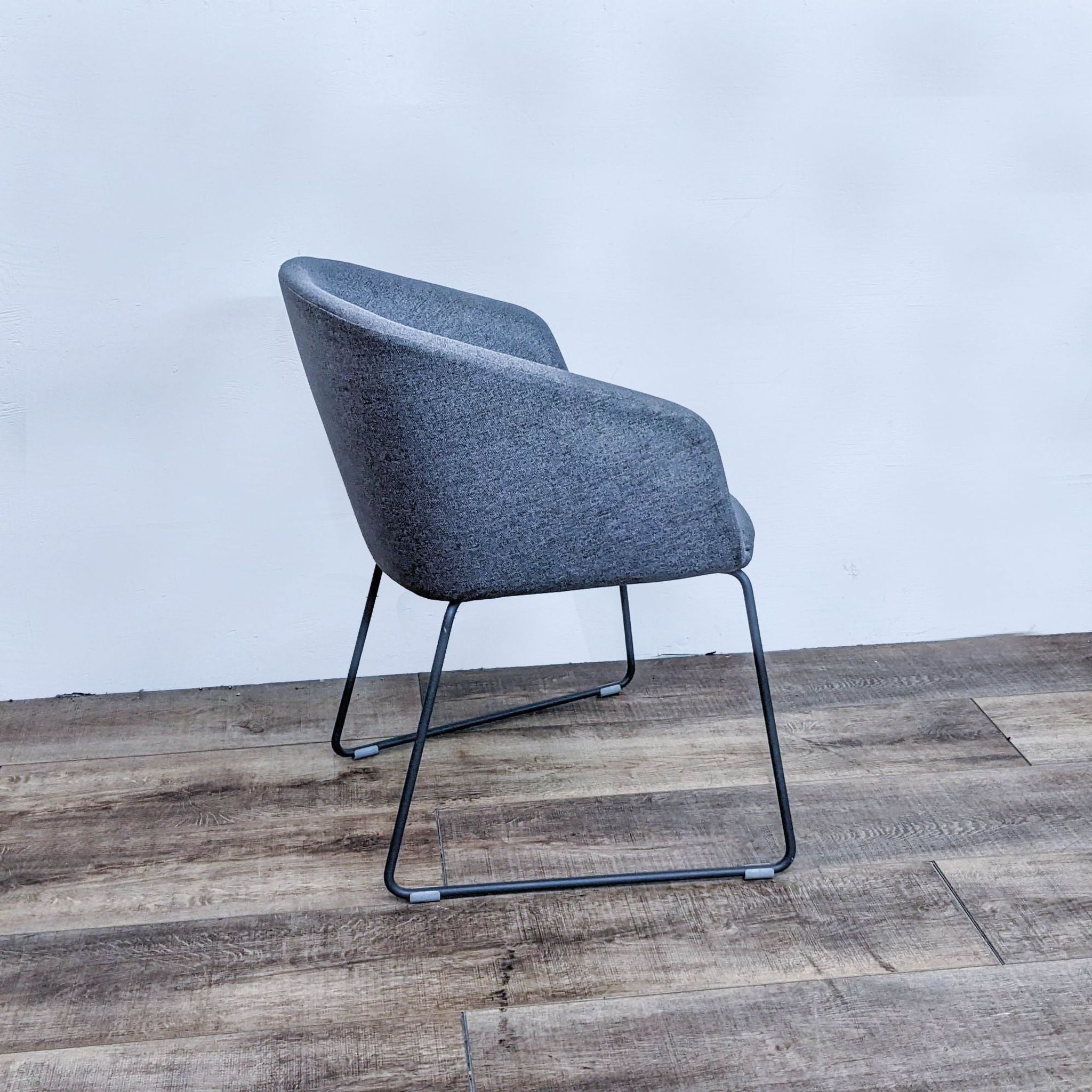 2. Side angle of the Poppin lounge chair displaying the curve of the upholstered backrest and the sturdy metal frame.