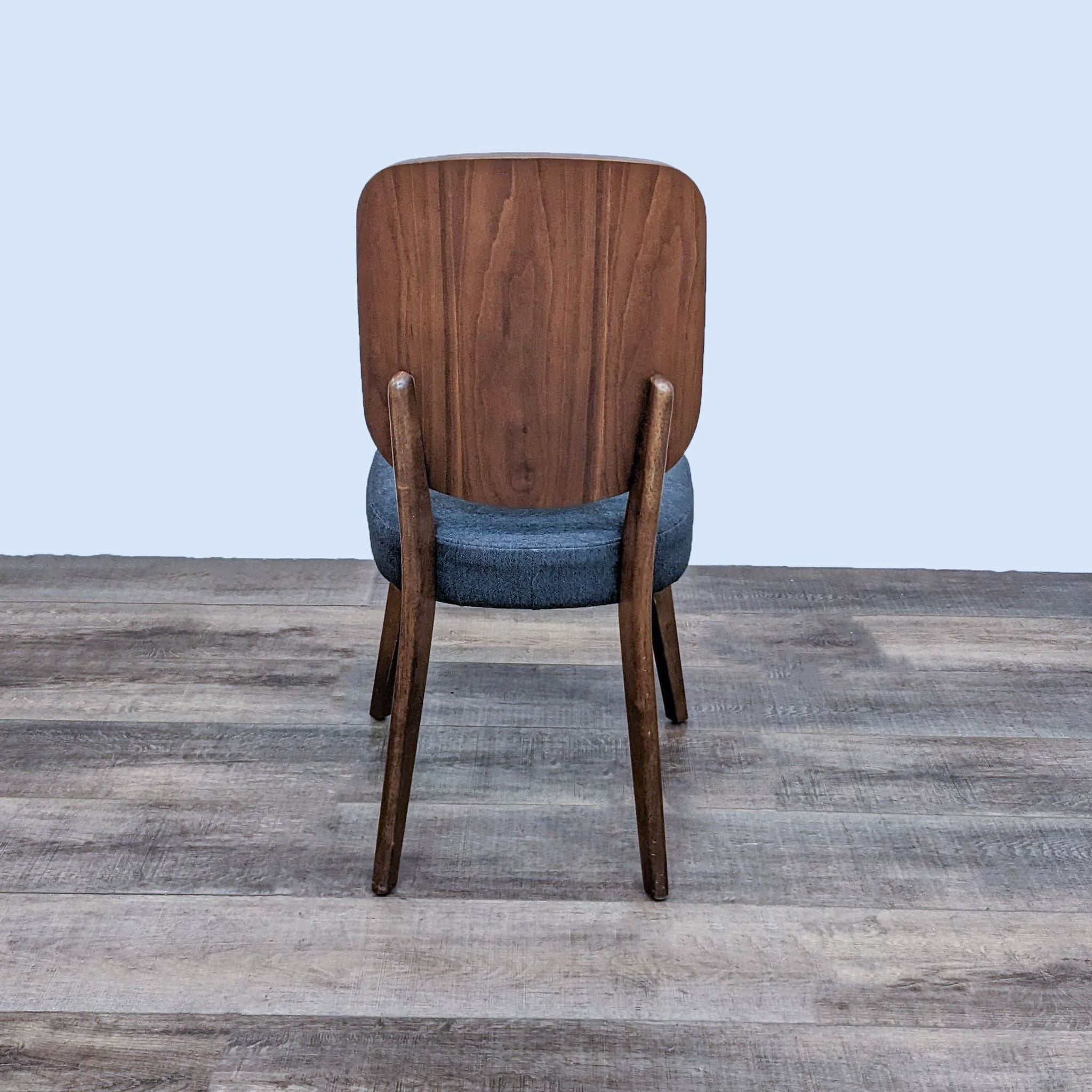 Retro-modern style Zuo Modern Alberta dining chair with curved wooden back and gray cushion on a wooden floor.