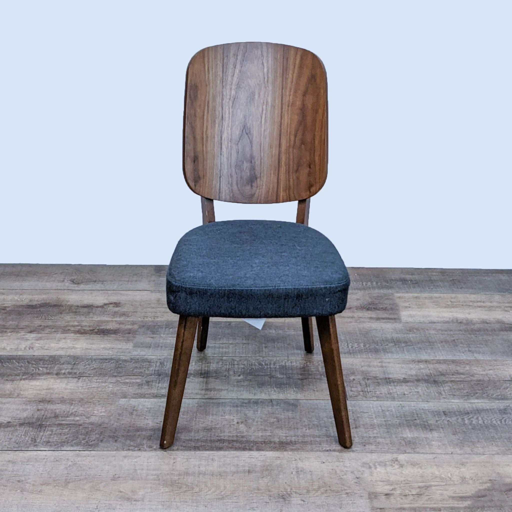 Zuo Modern Alberta dining chair with curved wooden back and gray cushion, retro-modern style, on wood floor.