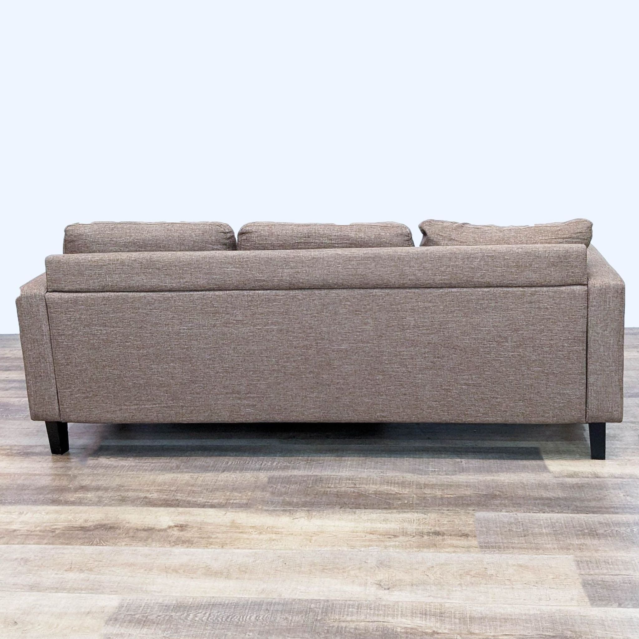 Beige Reperch 78" sectional sofa with reversible chaise, narrow arms, and dark feet on wood floor.