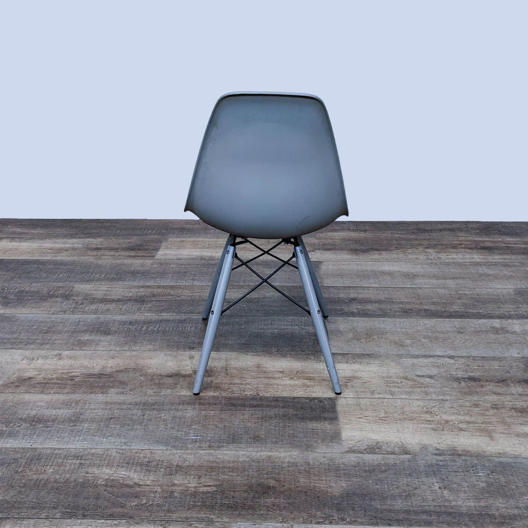 Reperch modern two-toned polypropylene side chair with an Eiffel-style base, placed on a wooden floor.