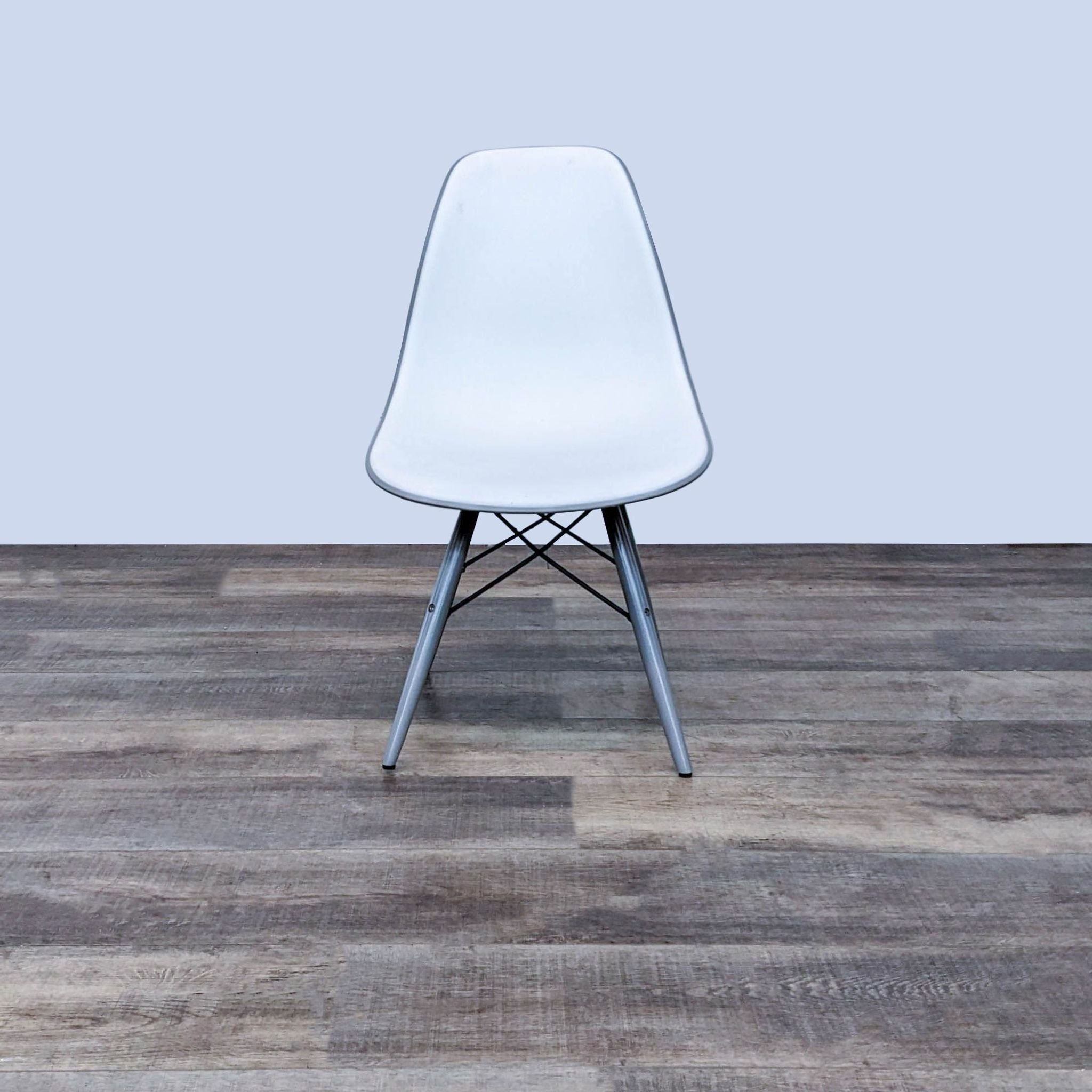 Reperch modern two-toned dining chair with white polypropylene seat and Eiffel-style metal base on wood floor.