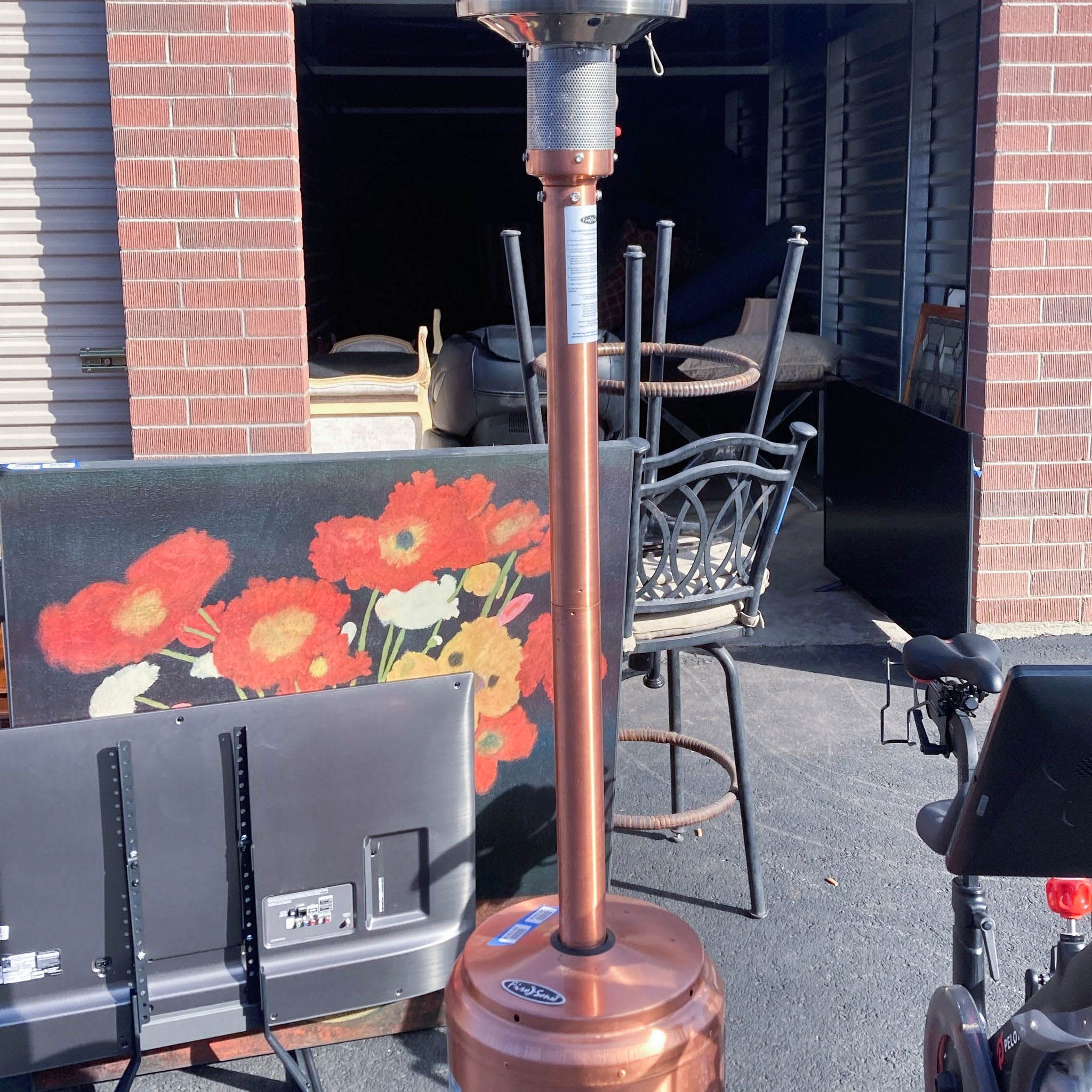 Outdoor Reperch patio heater beside a painting and patio furniture.