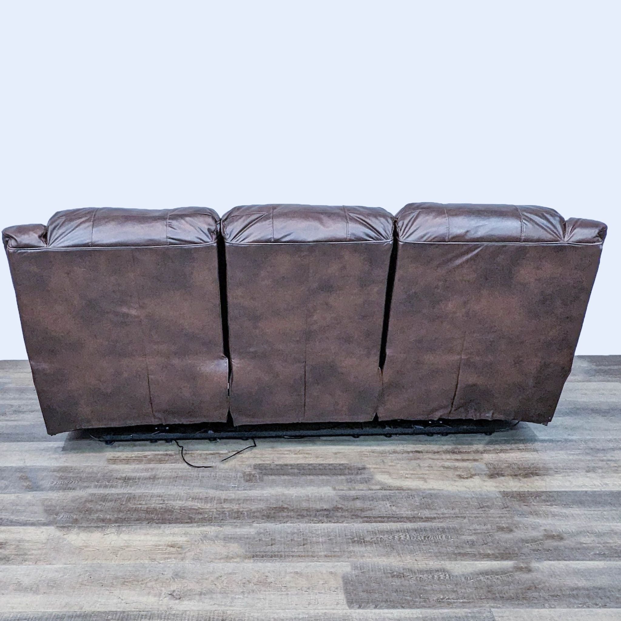 Ashley Furniture contemporary 3-seat brown leather dual reclining sofa with pillow top arms and high back.