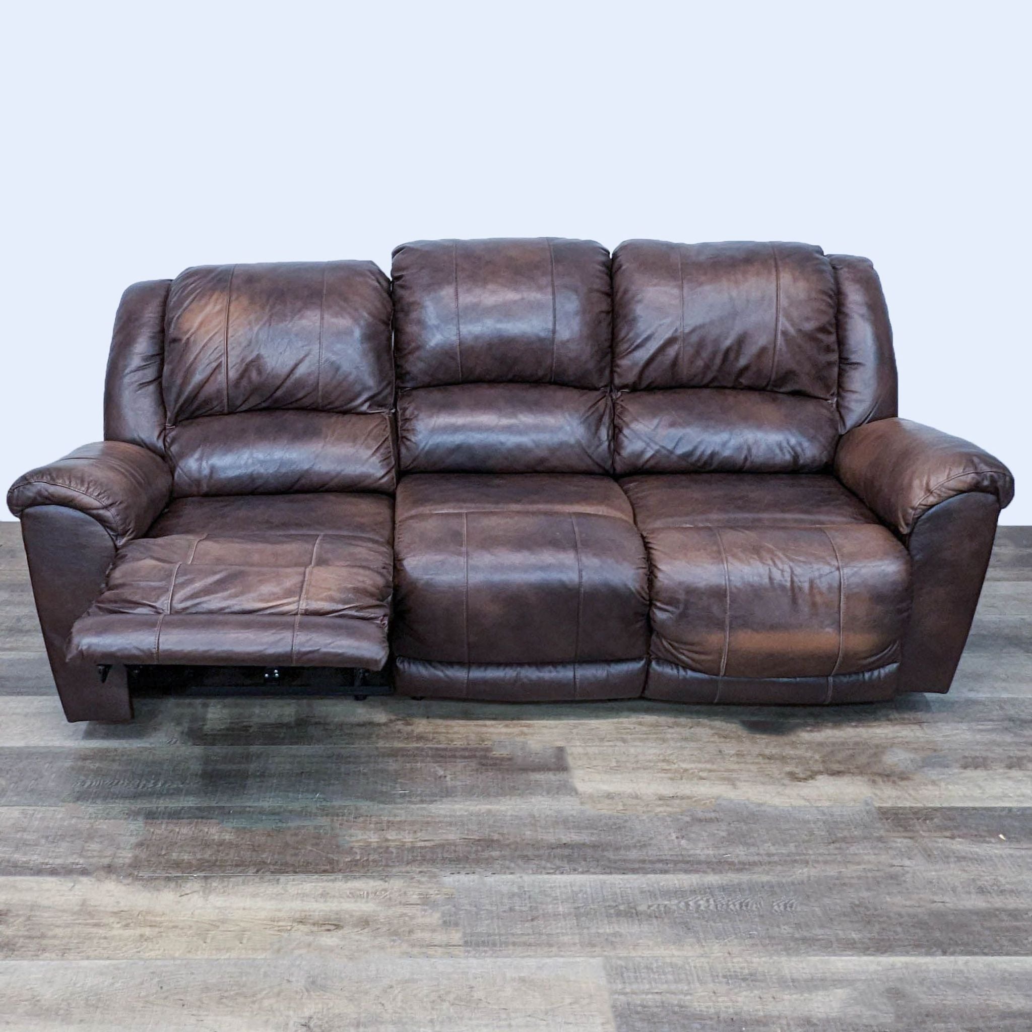 Ashley Furniture brown leather reclining sofa with pillow top arms, shown closed.