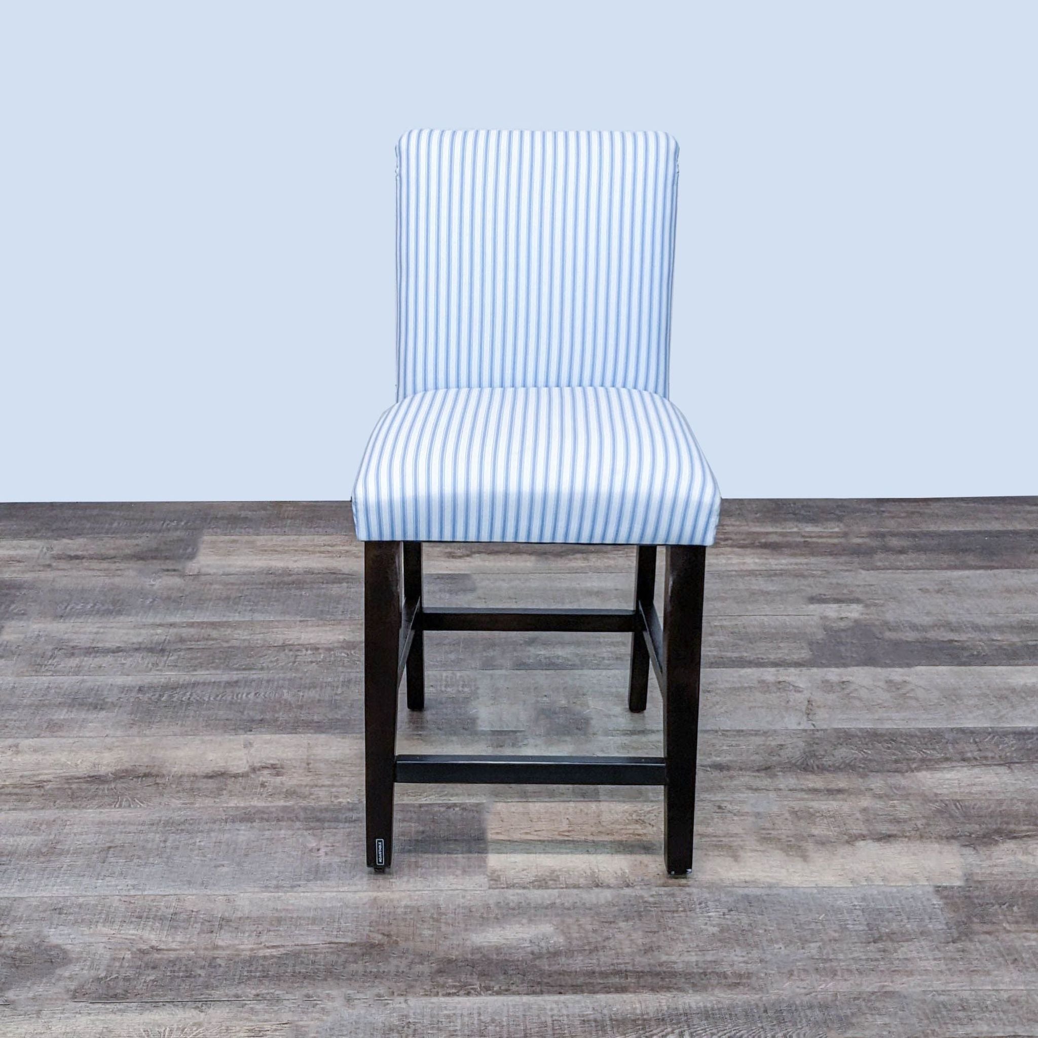 Blue and white striped upholstered counter stool by Skyline Furniture with a dark wooden base.