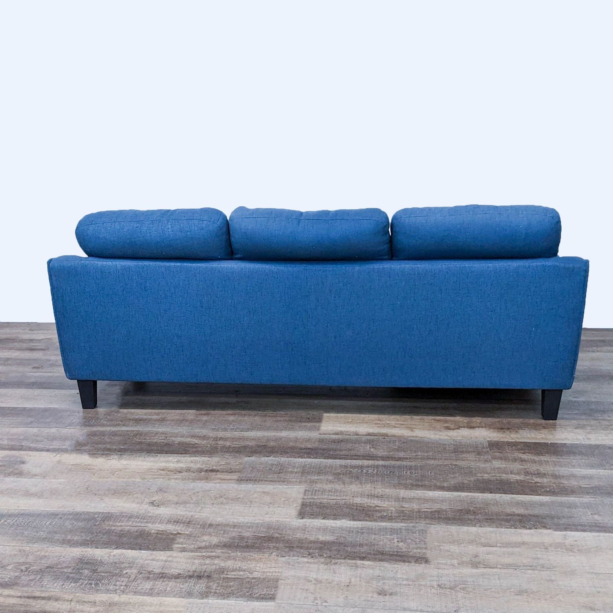 Blue Reperch sectional sofa with chaise and dark wood feet on wooden floor.