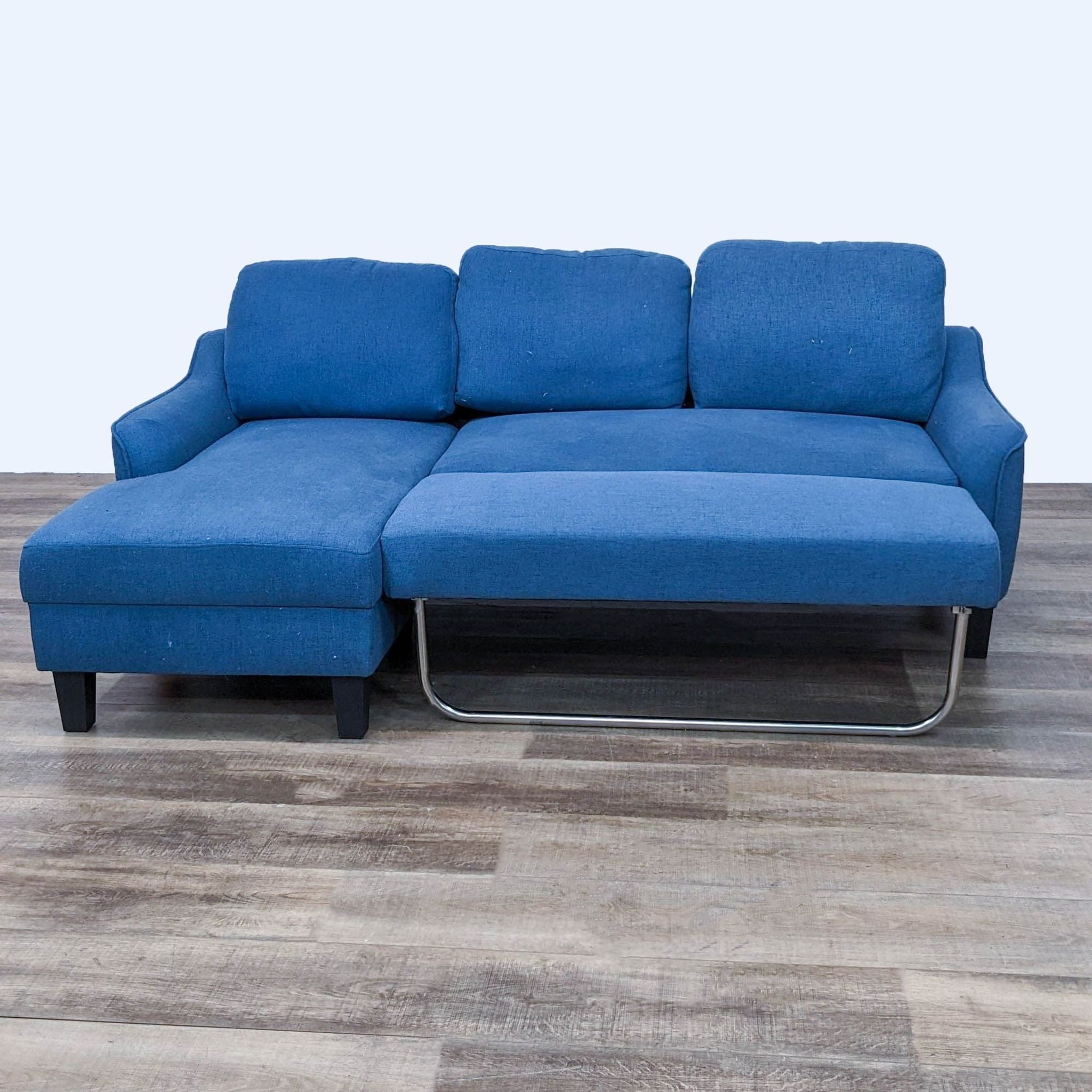 Blue Reperch sectional sofa with extendable sleeper space and metallic support, on laminated flooring.