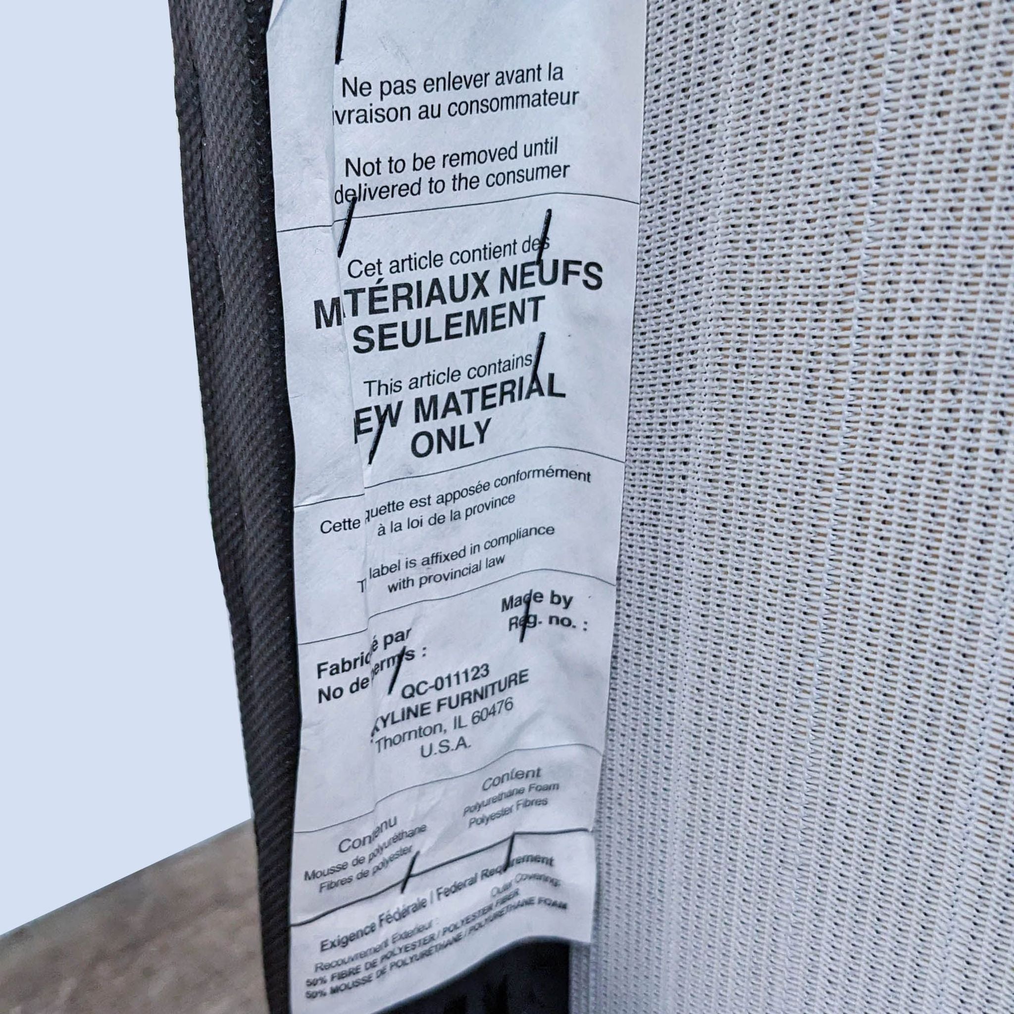 Close-up of a law label on a Skyline Furniture Hendrix chair with palm leaf print fabric and wood legs.