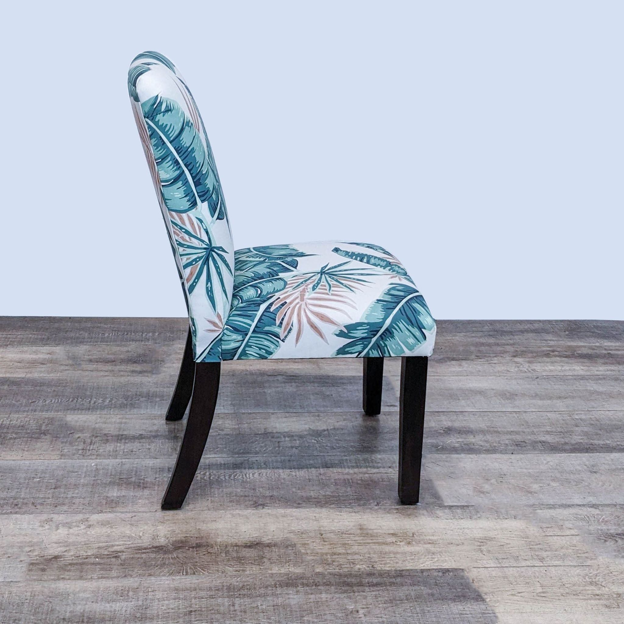 Upholstered dining chair by Skyline Furniture featuring a tropical palm leaf pattern on fabric with clean lines and wooden legs.