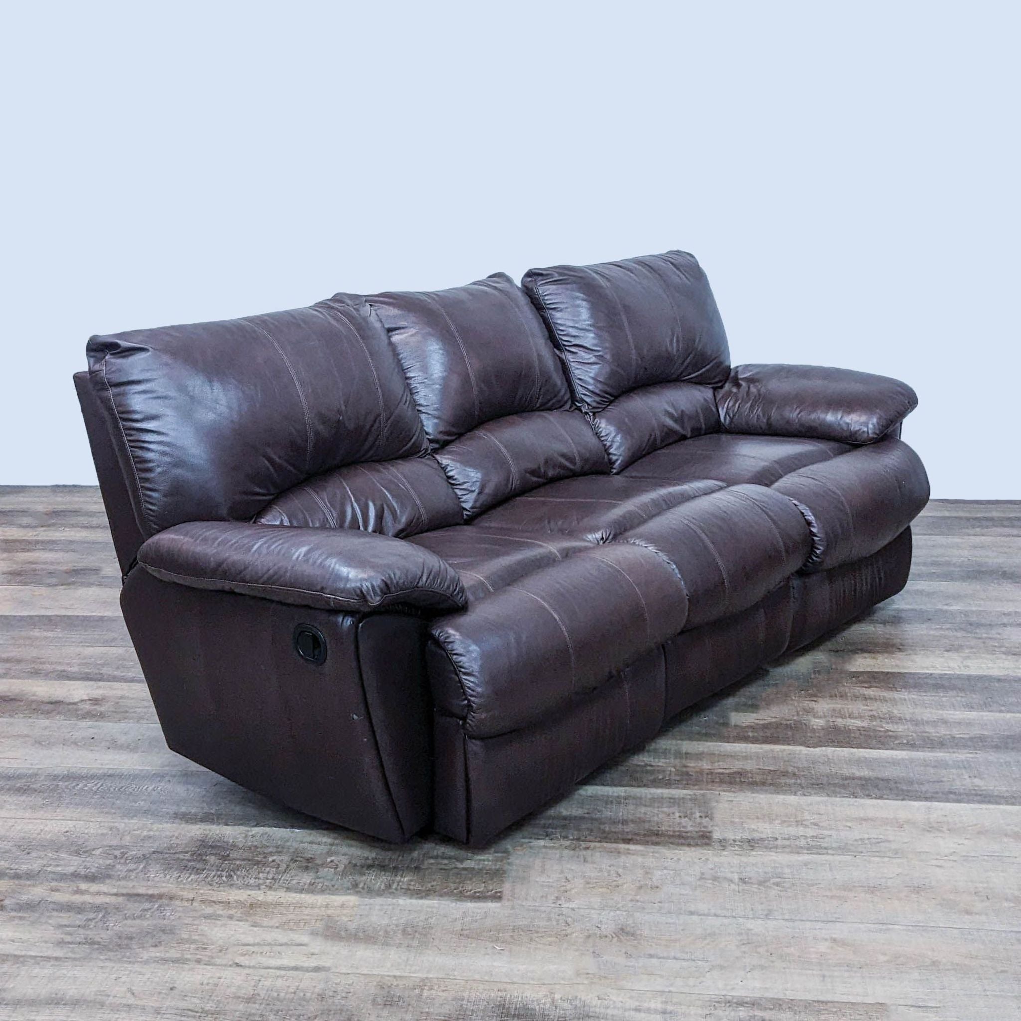Reperch 3-seat high back leather look sofa with pillow top arms on a wooden floor.