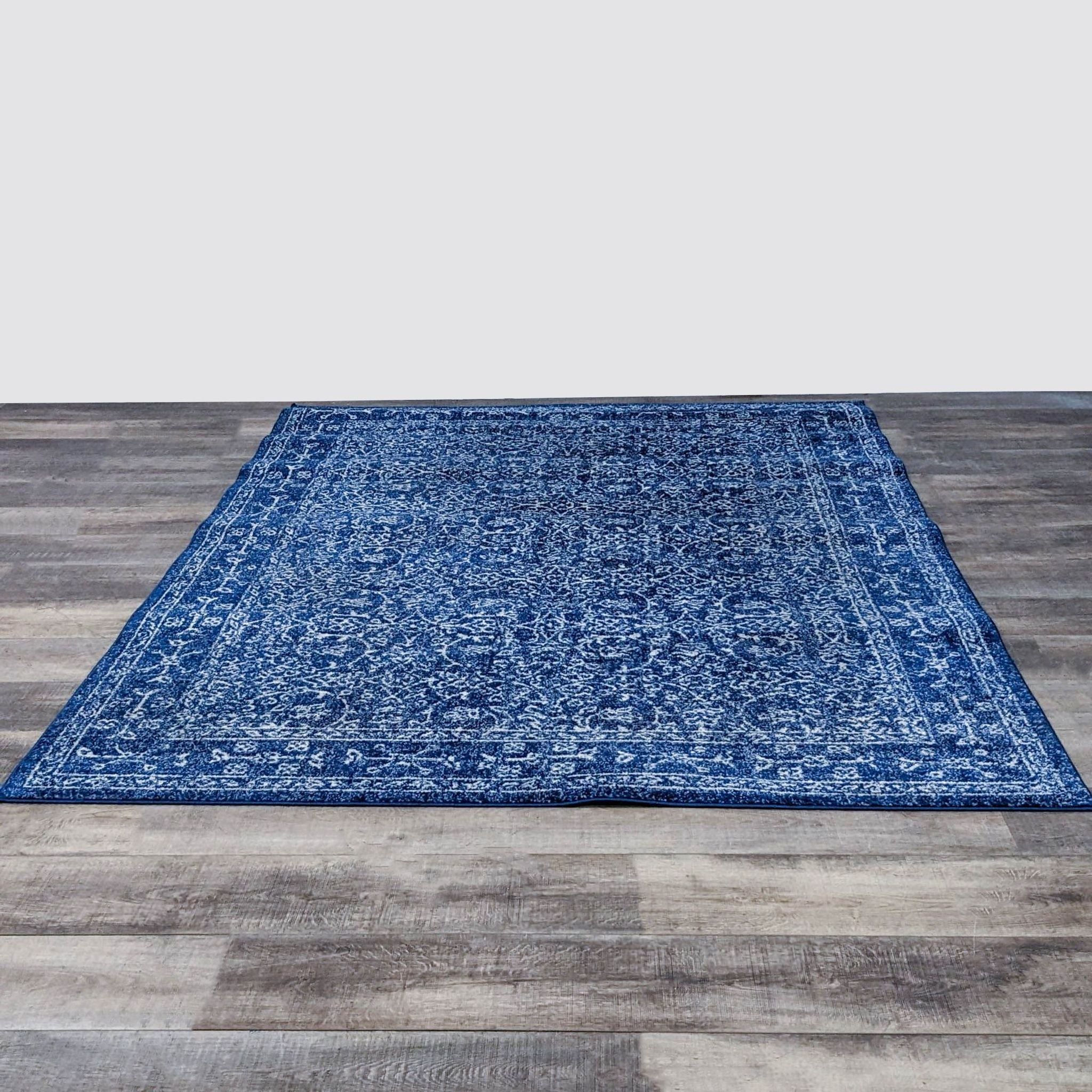 nuLOOM Waddell Vintage Oriental pattern 6'7"x9' area rug with dark blue tones and low pile, displayed on a wooden floor.