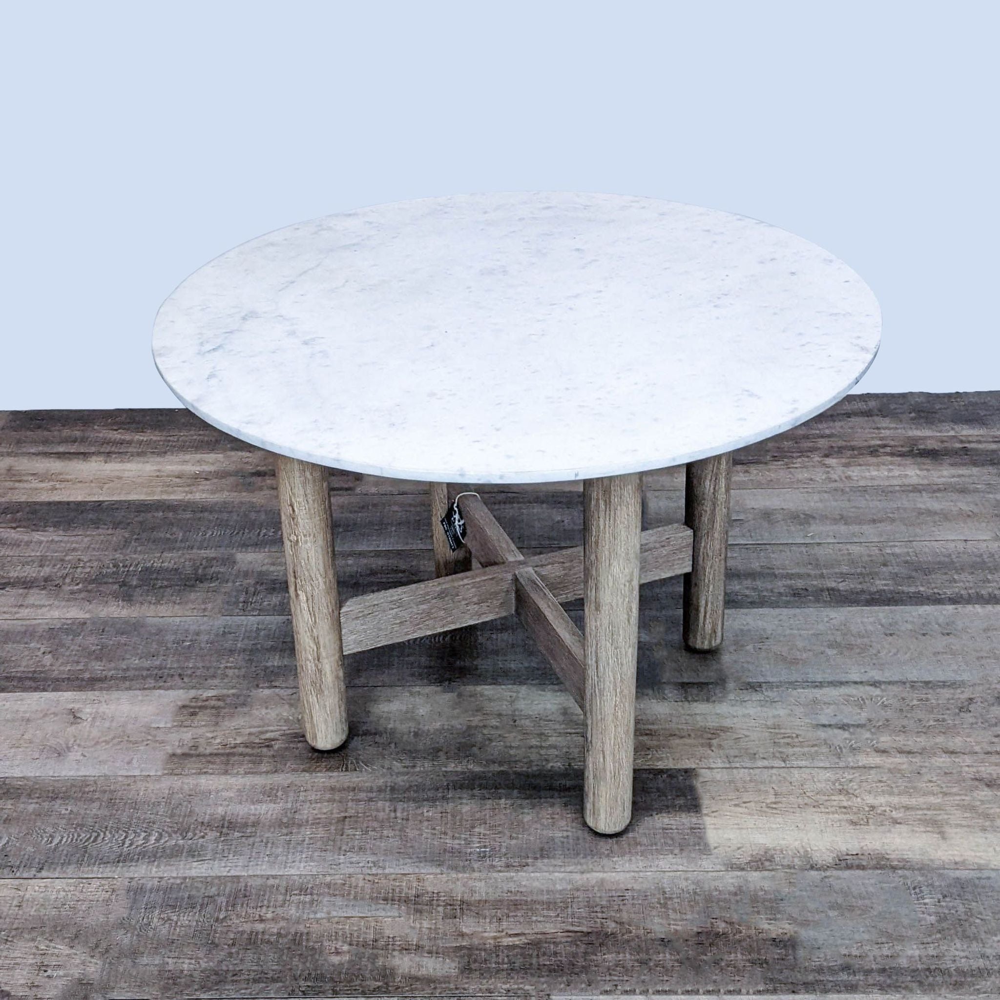 Round marble-top Hargrove table with robust wooden base paired with four wooden Berkshire chairs by West Elm.