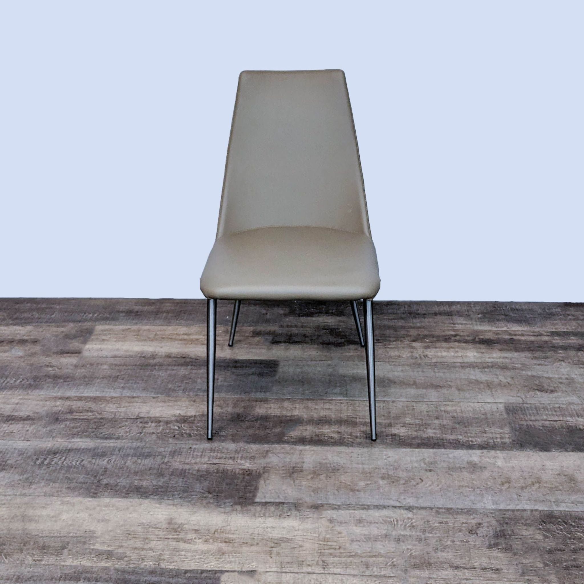 Alt text 1: Zuo Modern Whisp dining chair with a taupe leatherette seat and slim chrome legs against a wood-effect floor.