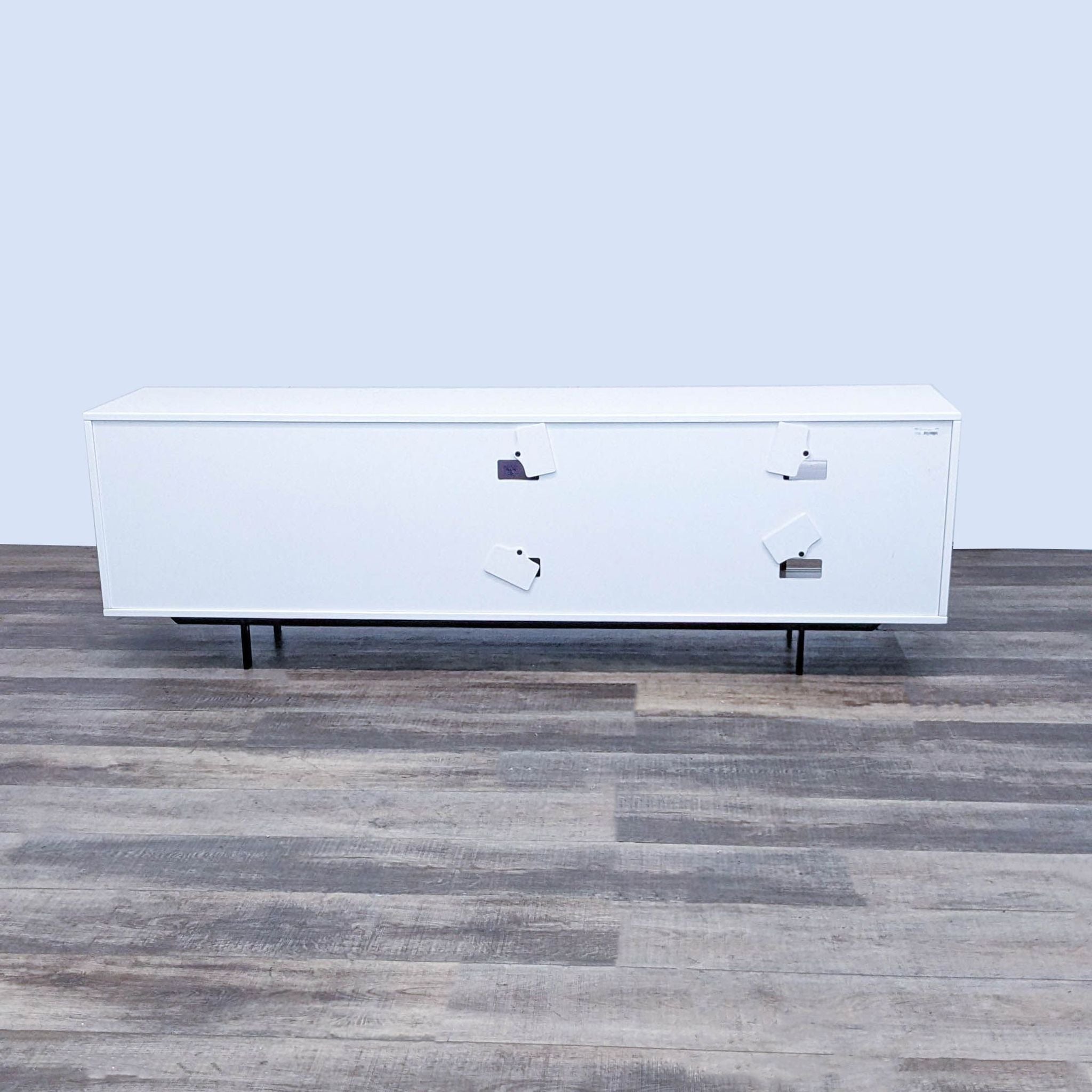 Alt text 2: Rear view of a white glossy Four Hands entertainment center with cable management cutouts and a product label visible on top.