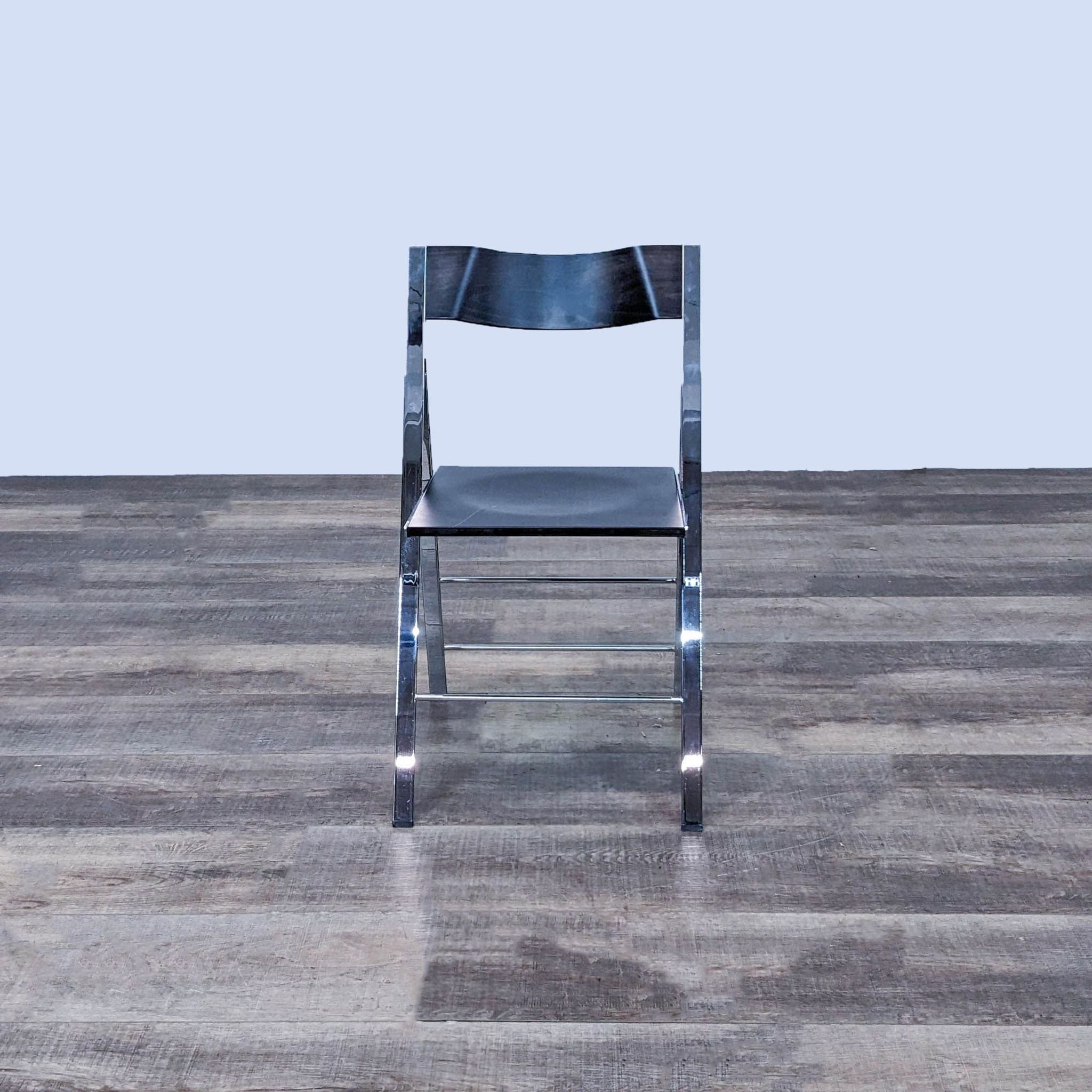 Alt text 1: Chrome foldable frame chair with dark wood seat and back, modern design, from Resource Furniture, displayed in profile view on wooden flooring.