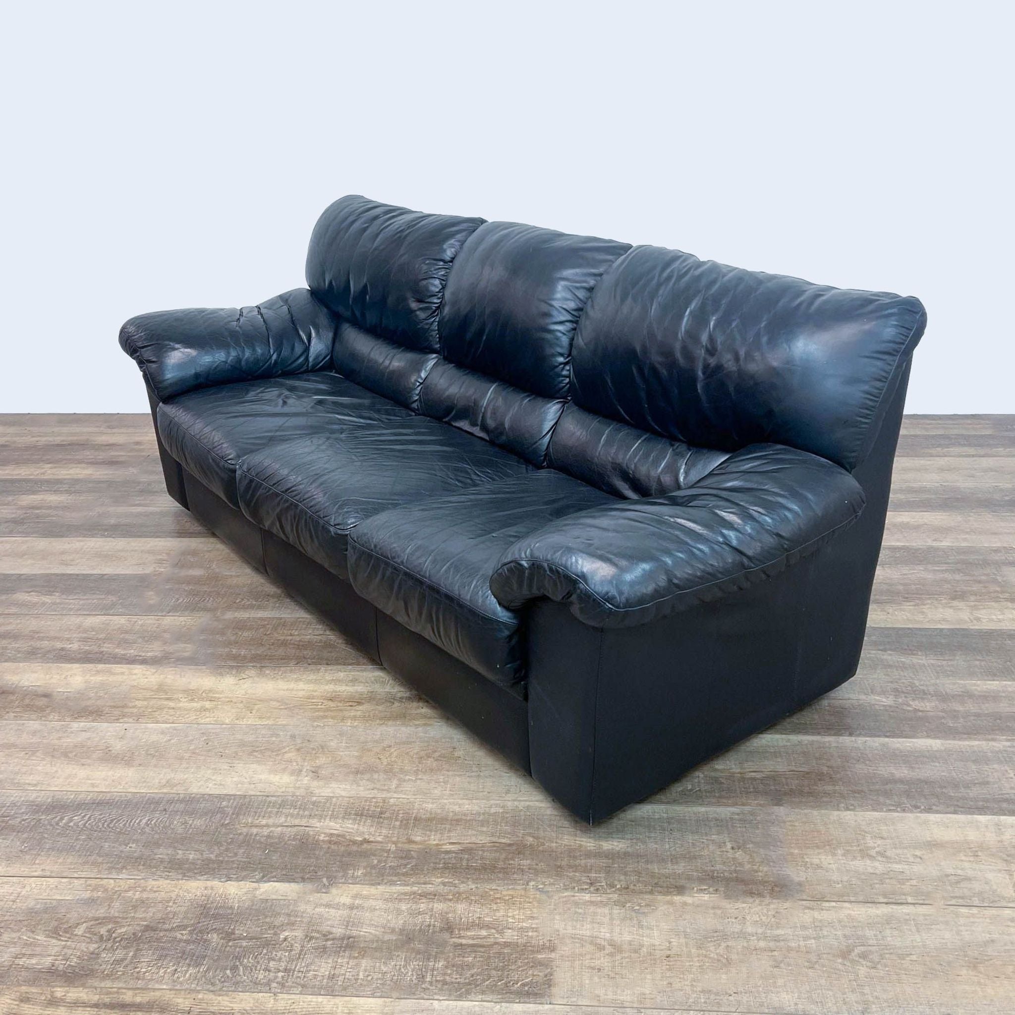 Contemporary Reperch leather sofa, featuring a 3-seat design with high back and cushioned arms, set against a neutral backdrop.