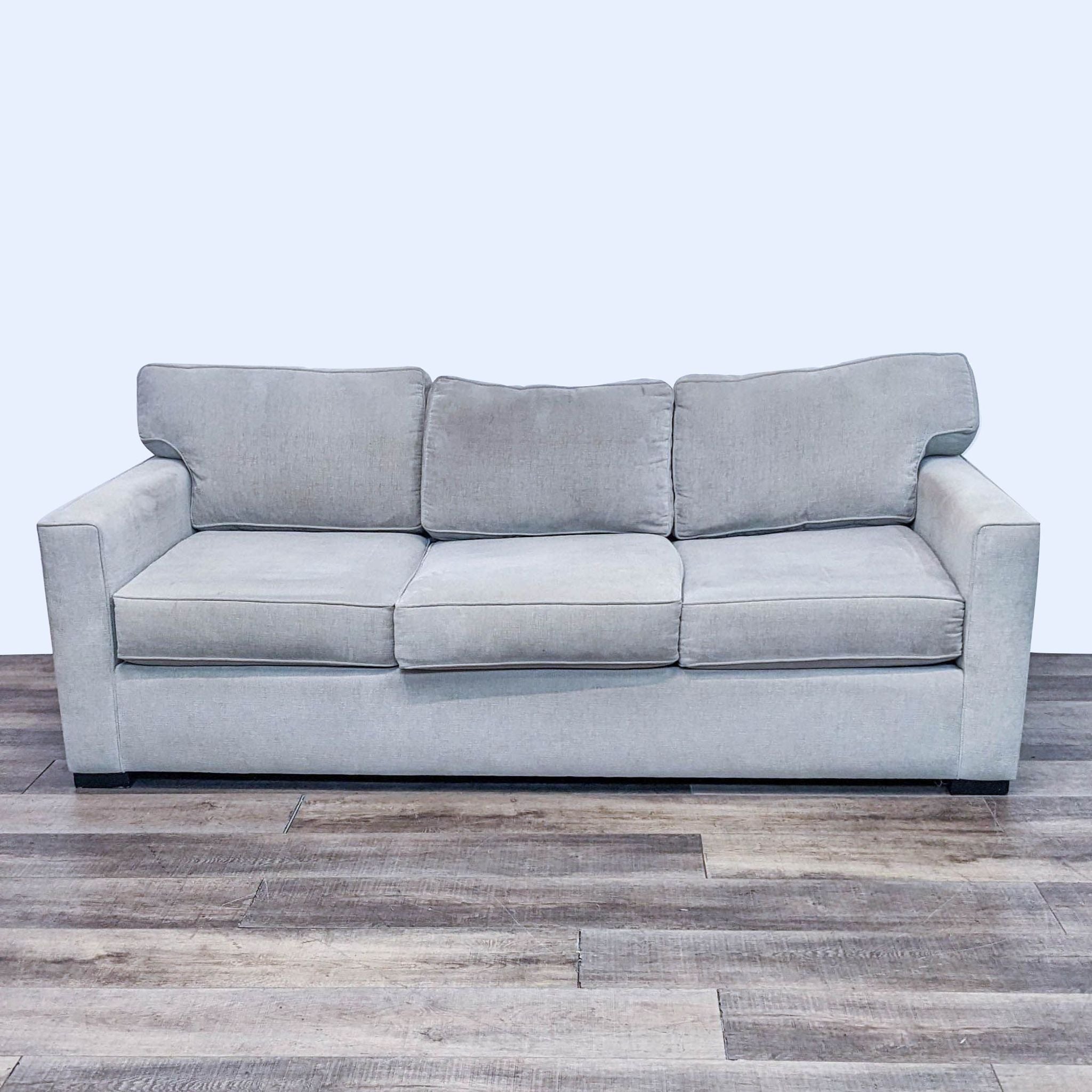 Beige 3-seat Living Spaces sofa with track arms and T-back cushions, upholstered, 85 inches wide.