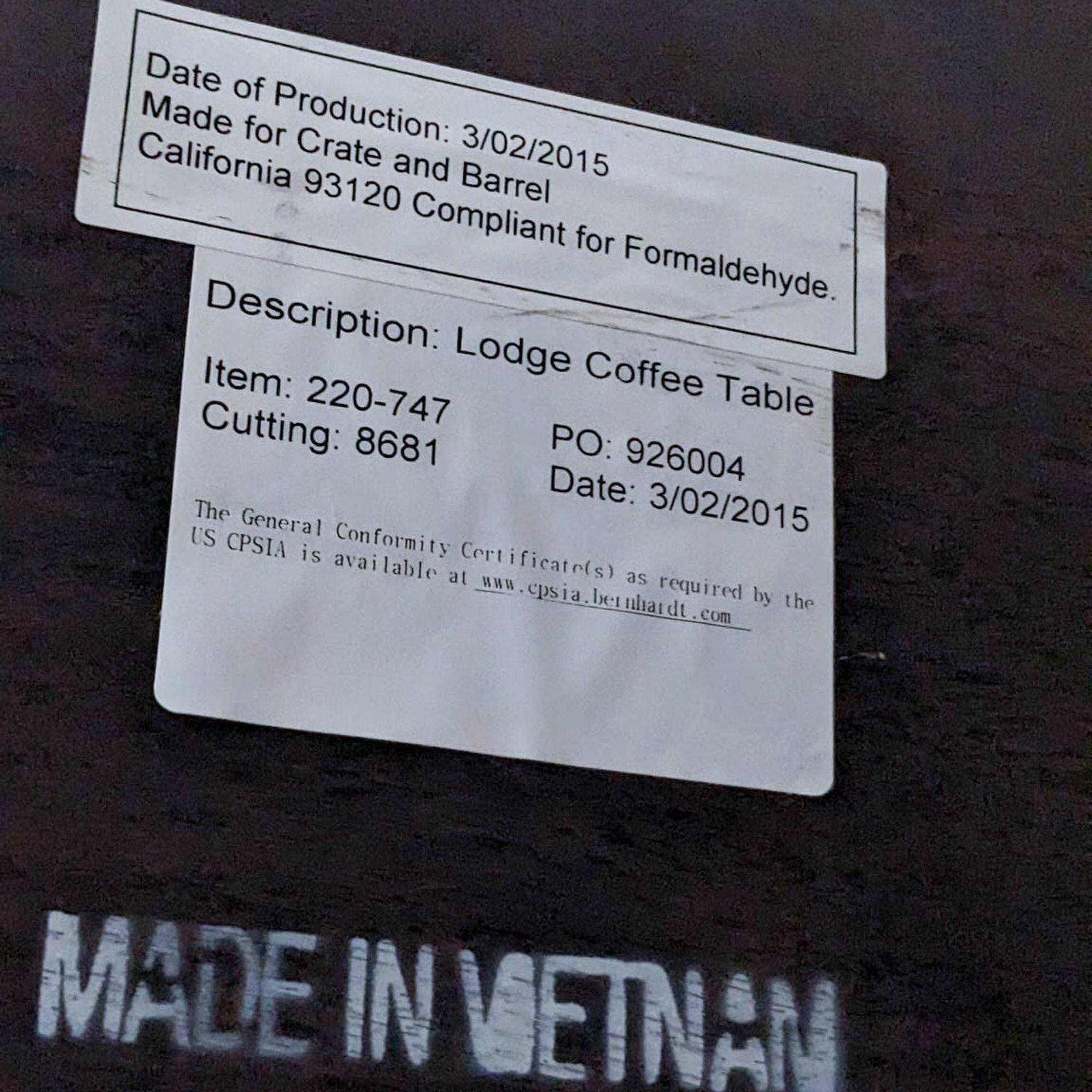Close-up of the manufacturing label on a Crate & Barrel Lodge Coffee Table showing compliance and item details.