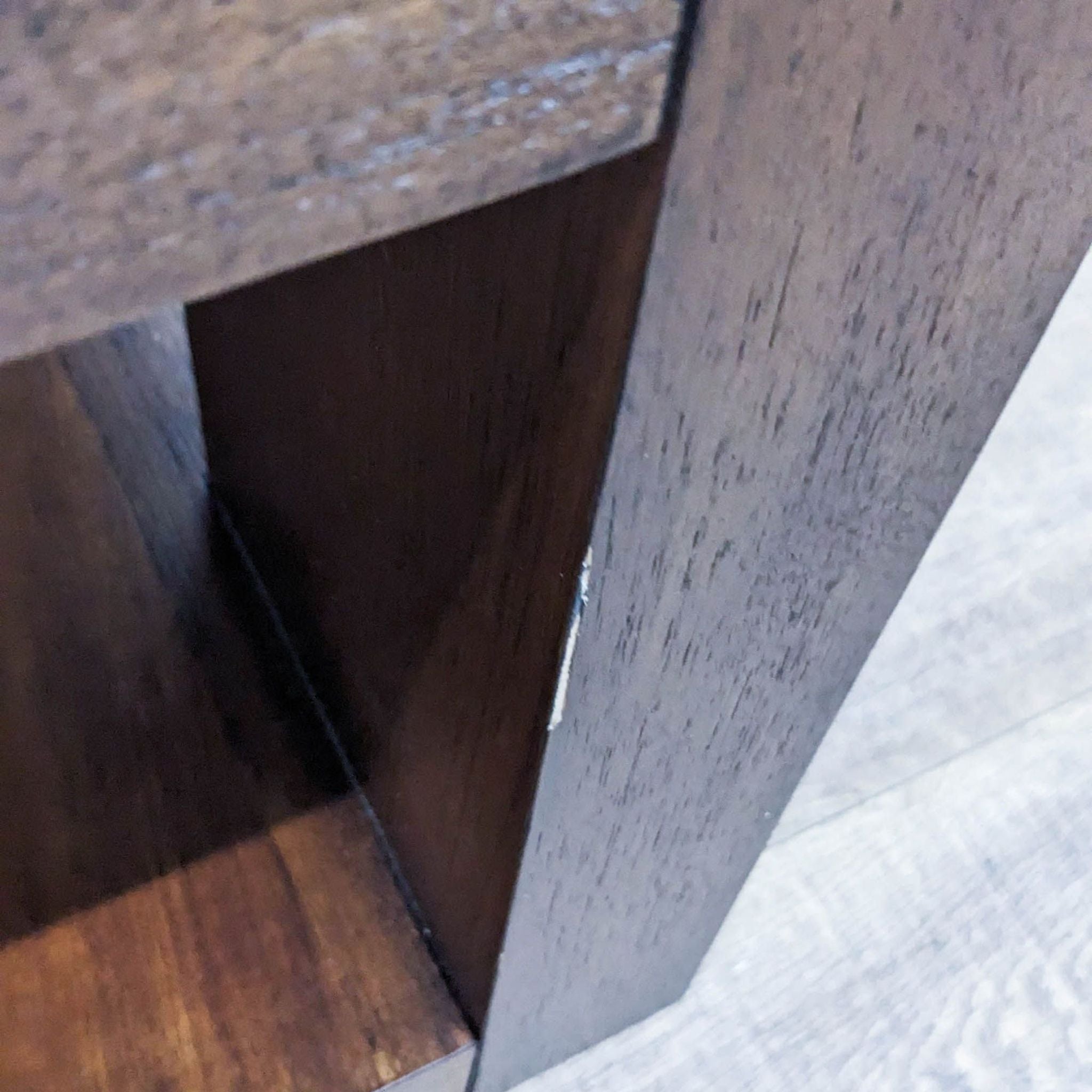 Close-up of Crate & Barrel coffee table corner showing the textured surface and recessed leg structure.