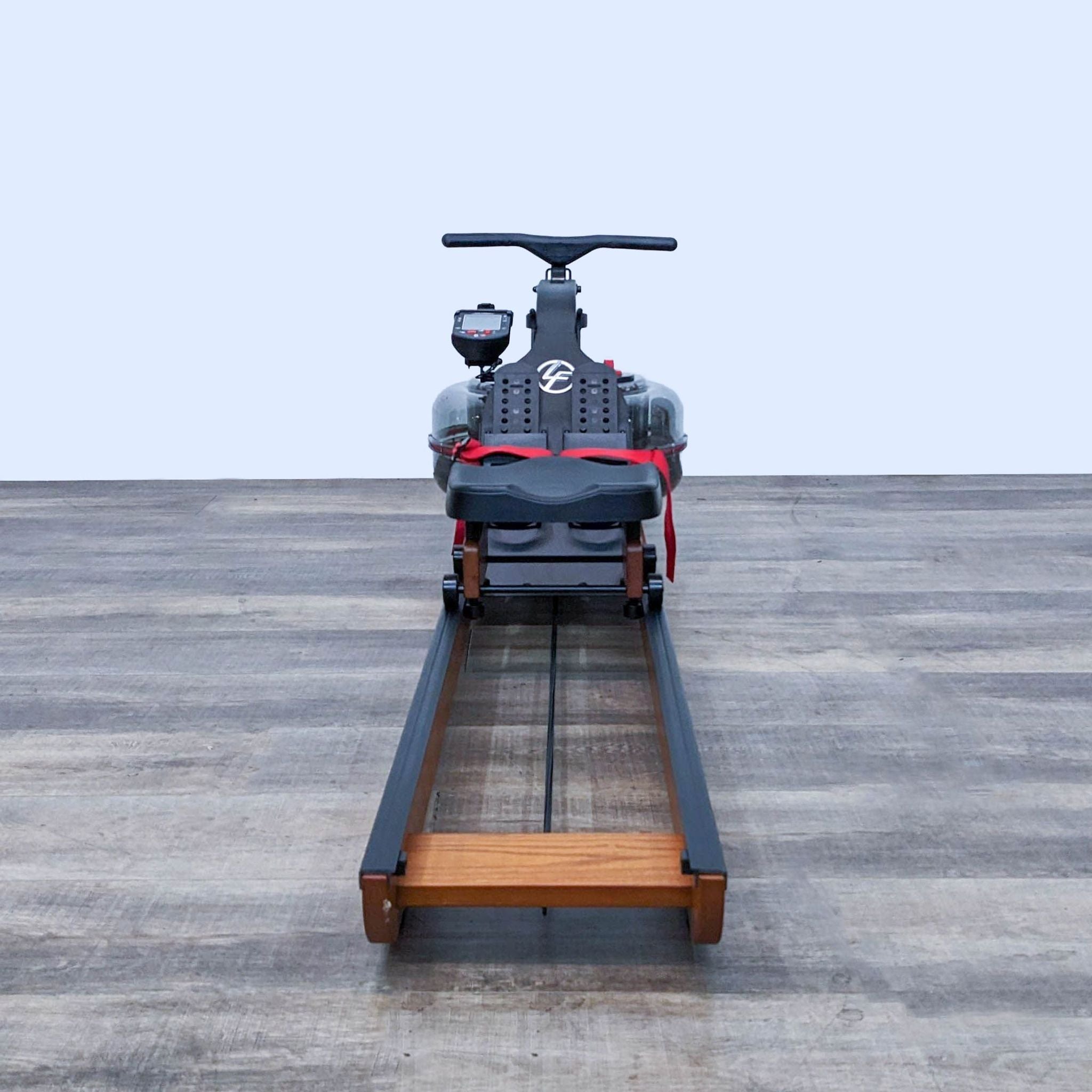 Life Fitness rowing machine with clear water tank facing front on wood flooring.
