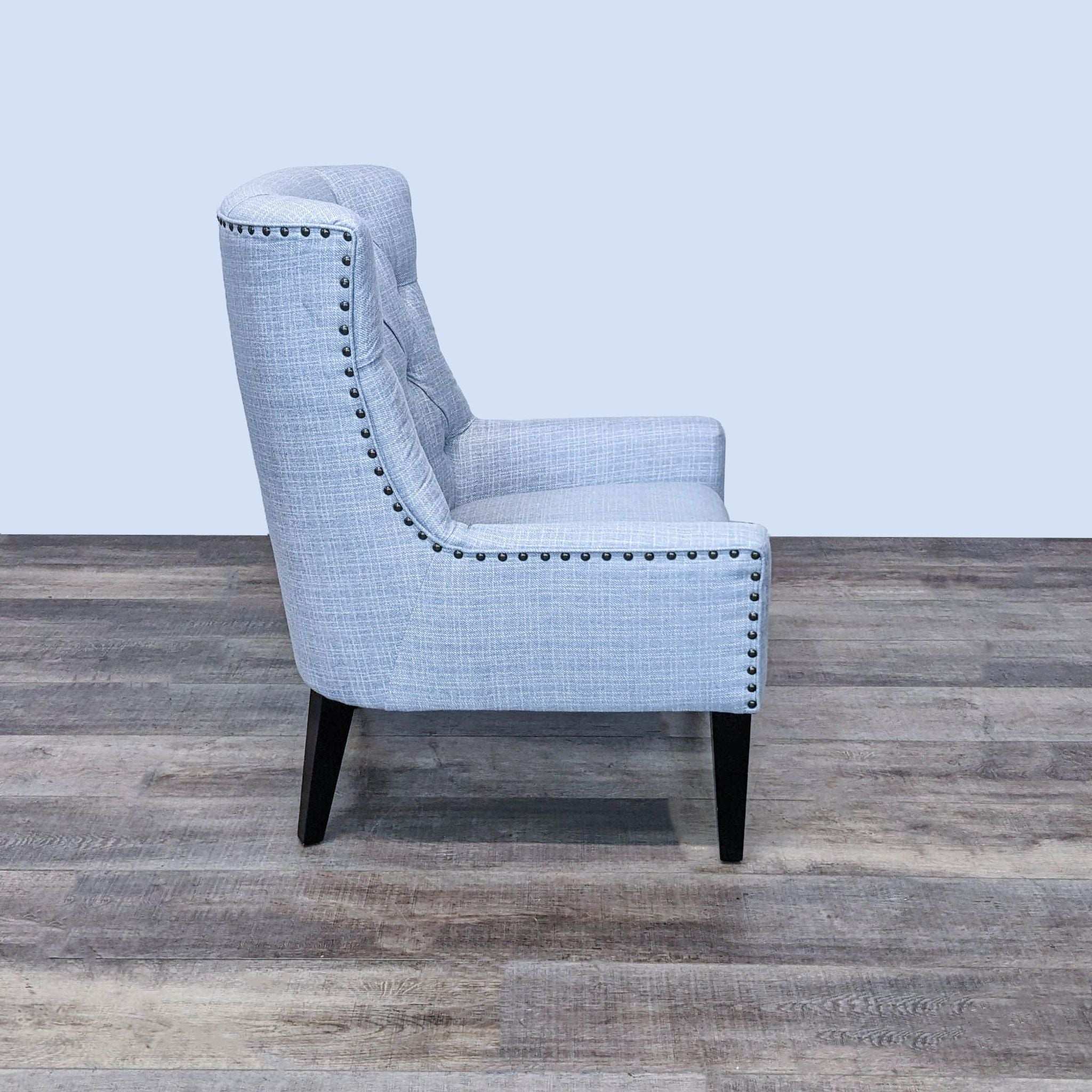 Pier 1 elegant lounge chair showcasing side angle with nailhead trim and curve detailing on light fabric.