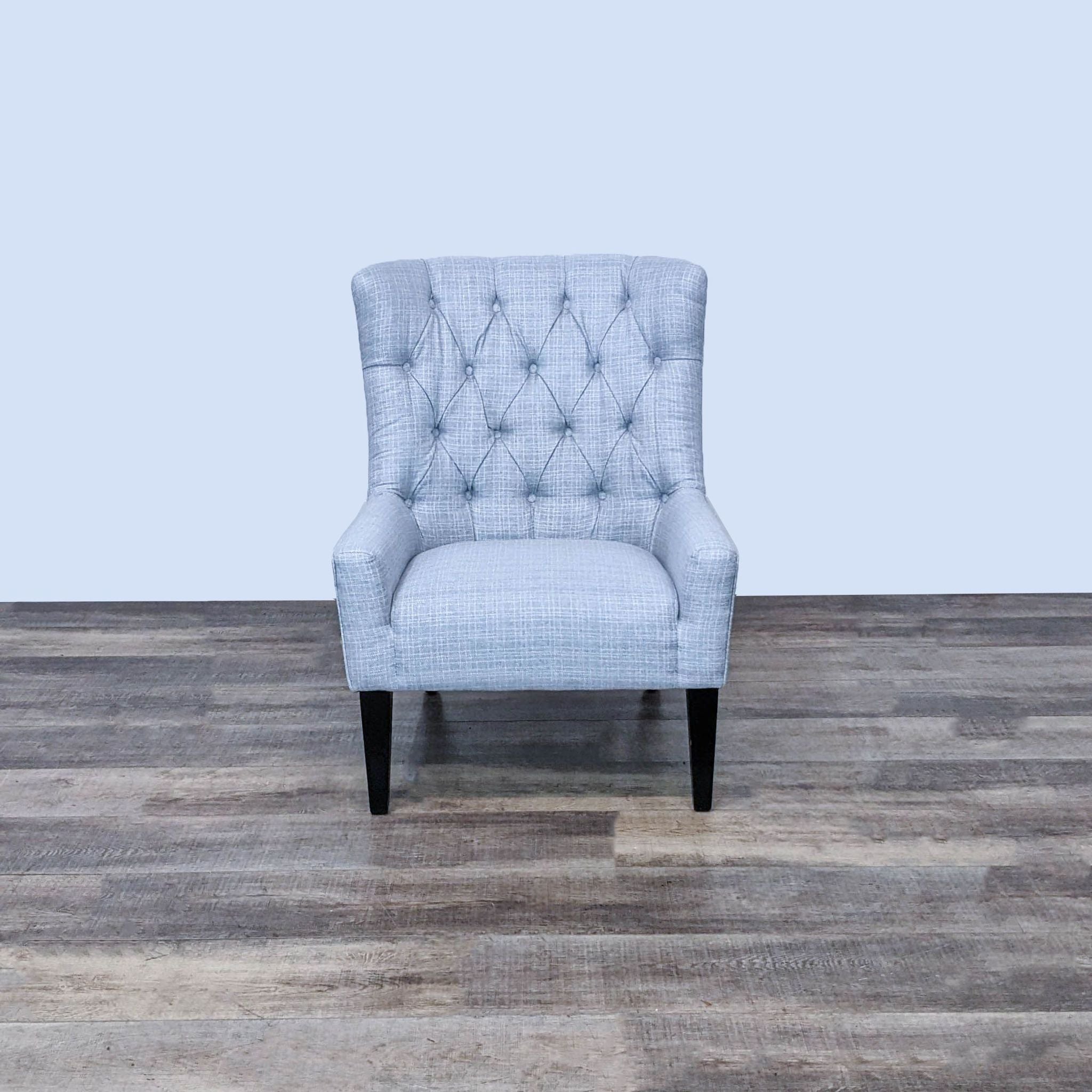 Pier 1 transitional wingback chair with button tufting, nailhead trim, and tapered ebony wood legs.